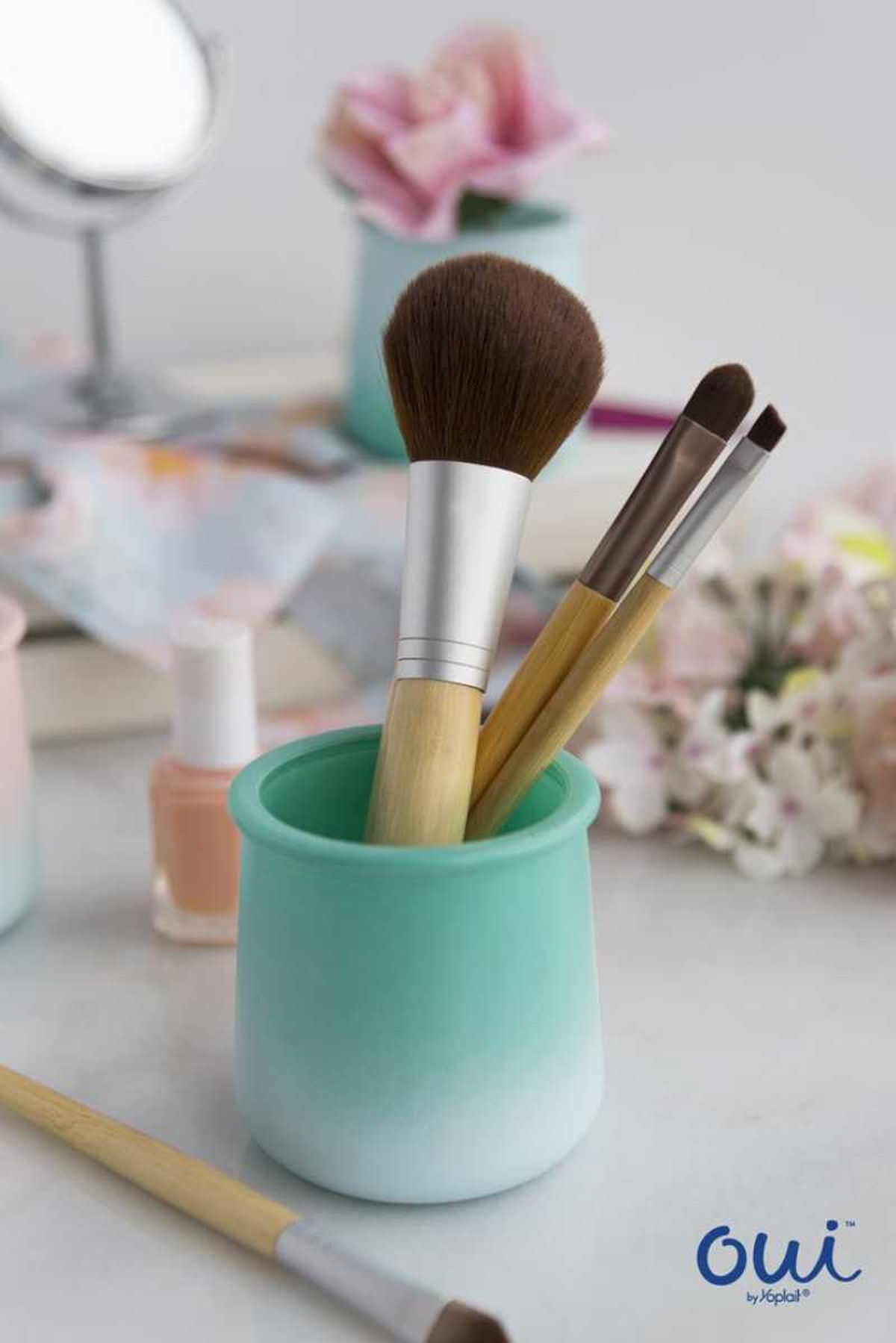 Tarro de yogur pintado con brocha y pinceles de maquillaje.