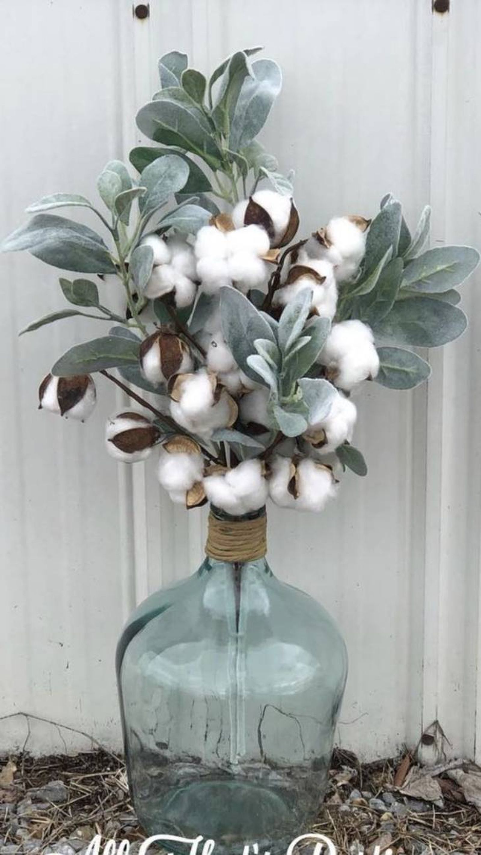 Damajuana decorada con flores de algodón.