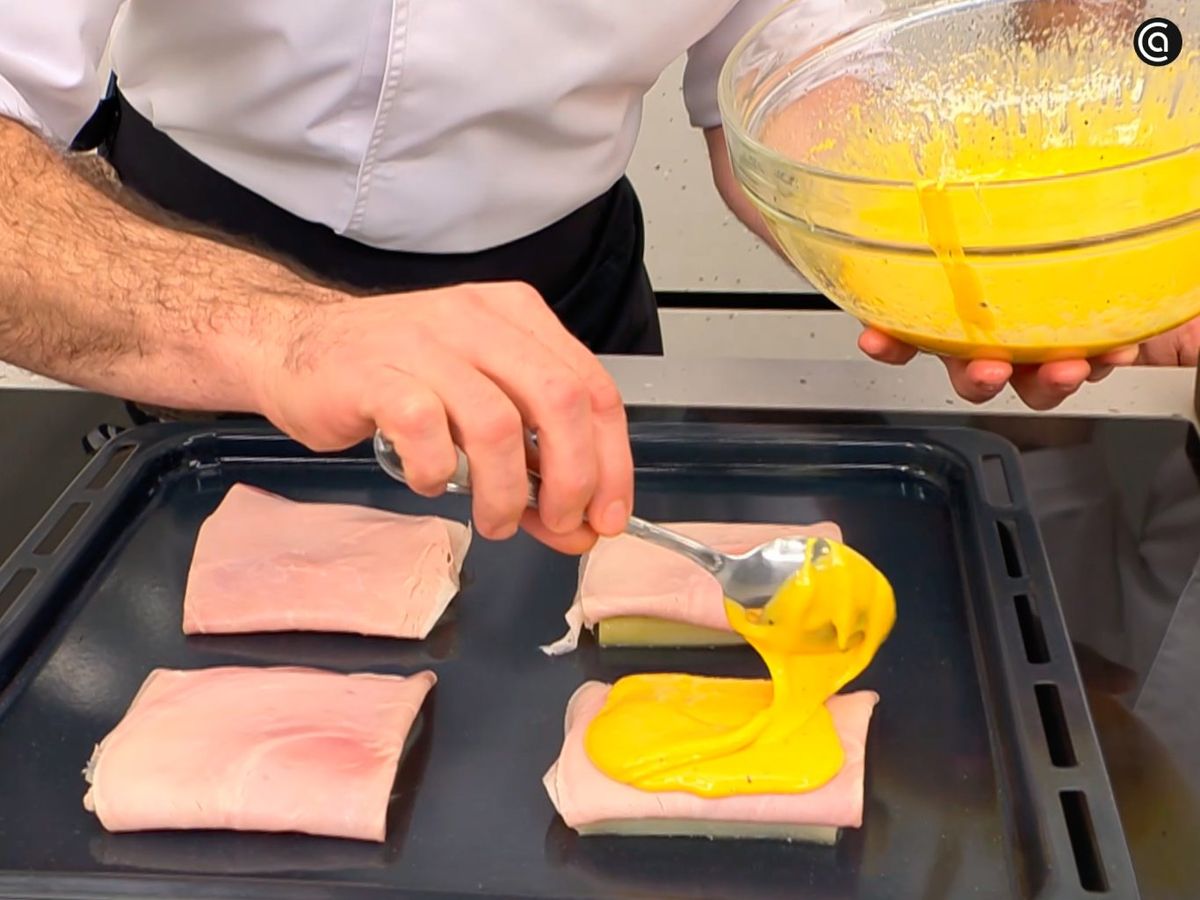 Vierte la emulsión de yemas sobre los puerros y el jamón, y gratina