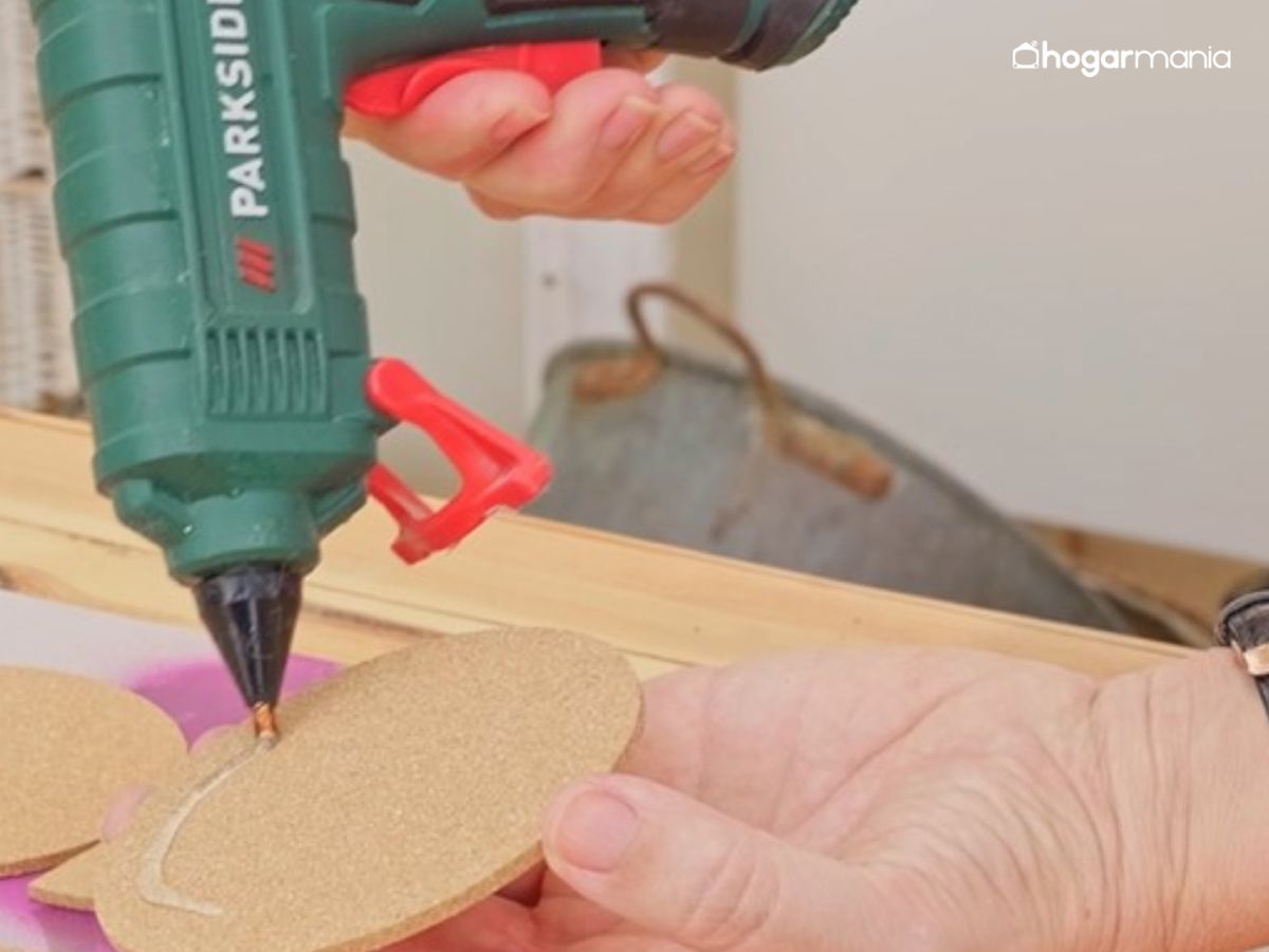 Se aplica silicona caliente en la parte trasera de cada pieza y se van pegando una a una sobre la base, respetando el diseño elegido.