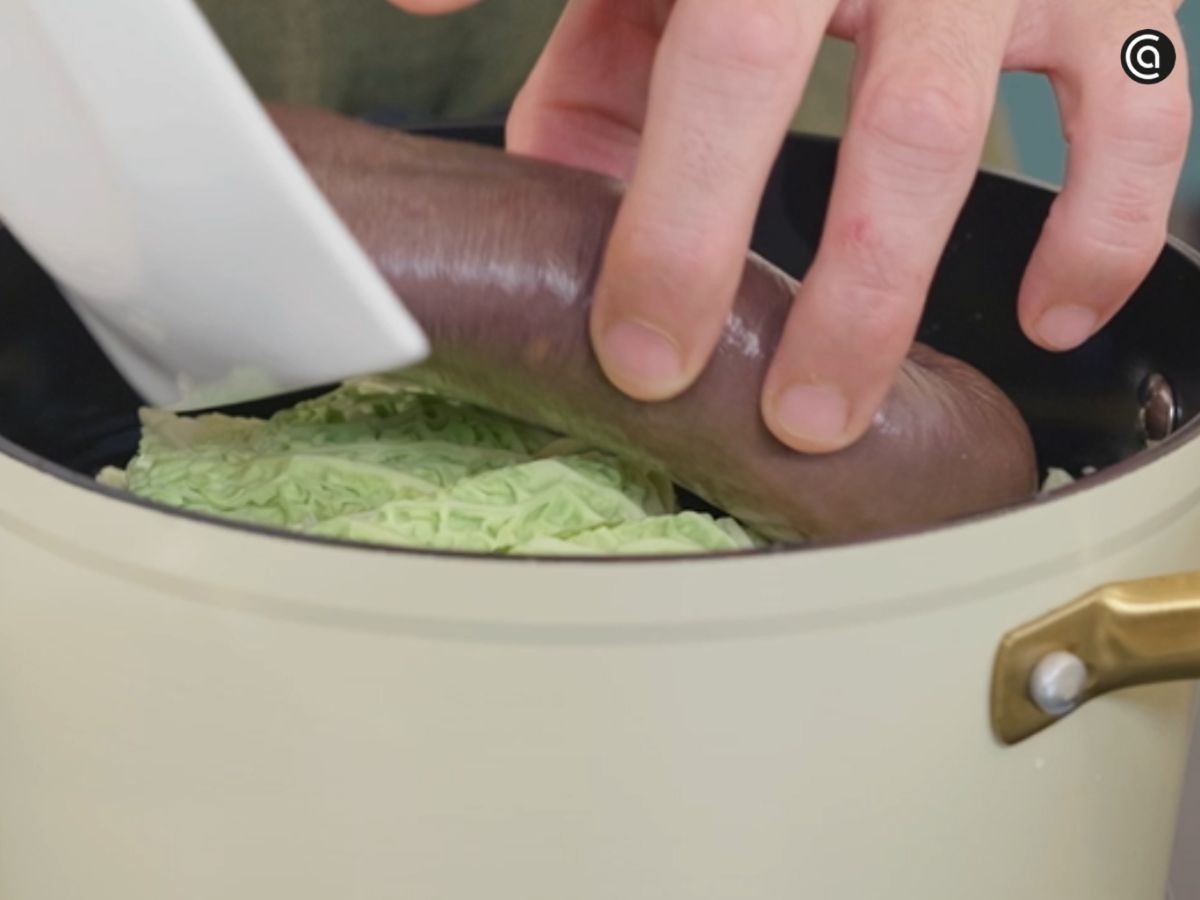 Se colocan las morcillas y el repollo en otra olla para cocinarlas lentamente sin que se rompan.