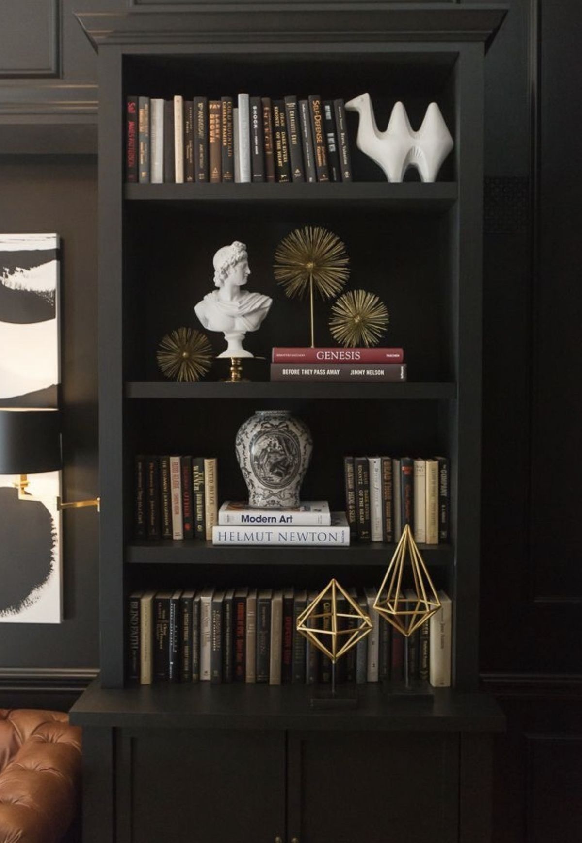 Estantería elegante de madera oscura con libros.