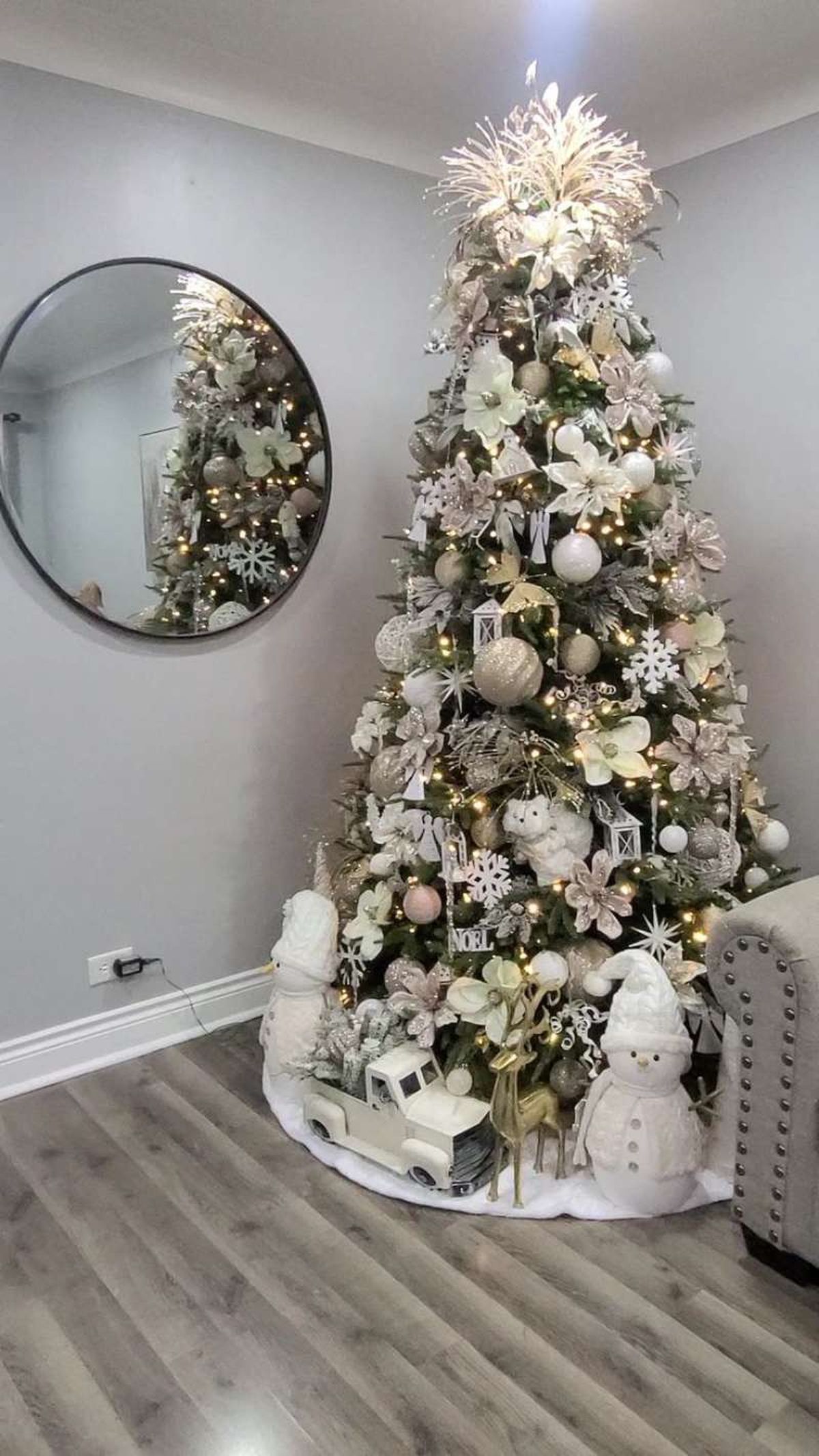 Árbol de Navidad con el pie adornado con figuritas navideñas.