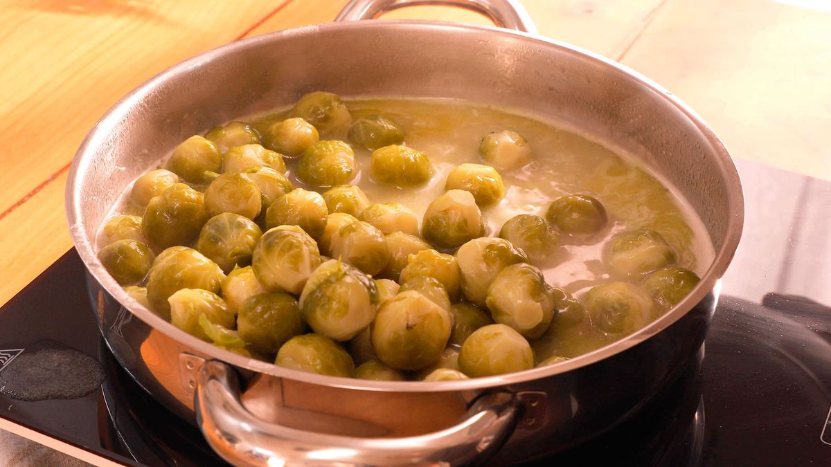 Incorpora el vino blanco y el agua de cocción a las coles de Bruselas para realzar su sabor y deja cocinar unos minutos