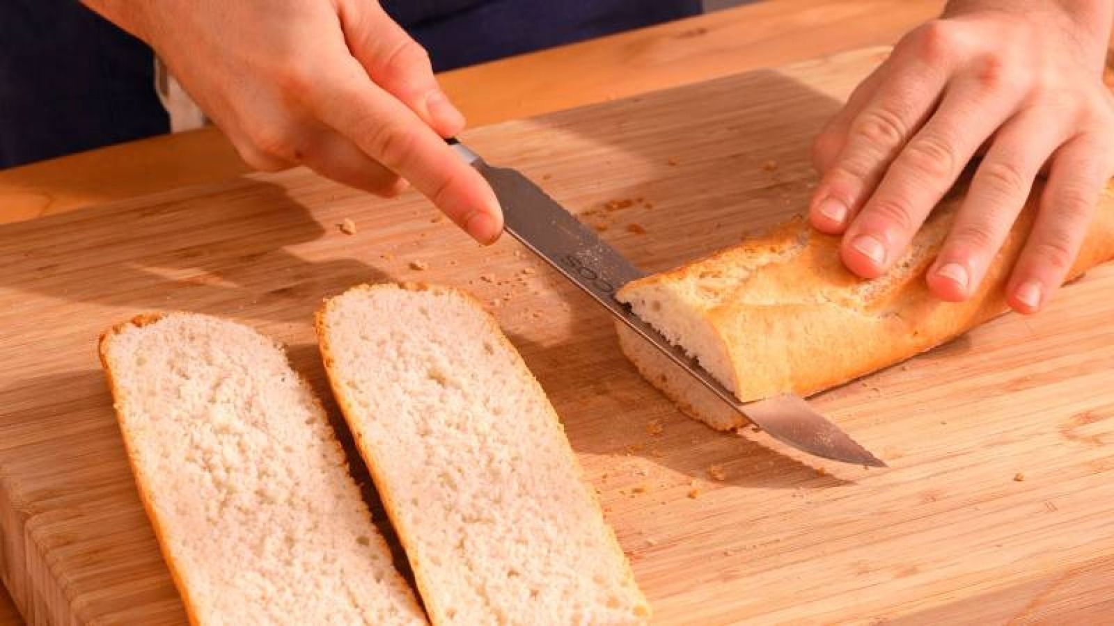 Corta la barra de pan en cuatro partes para preparar tus paninis caseros Corta la barra de pan en cuatro partes para preparar tus paninis caseros