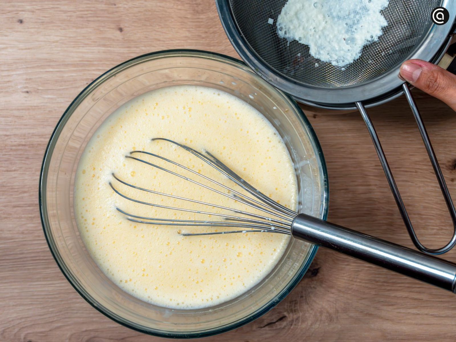 Pasa la leche infusionada por un colador y añádela a la mezcla de huevos y azúcar