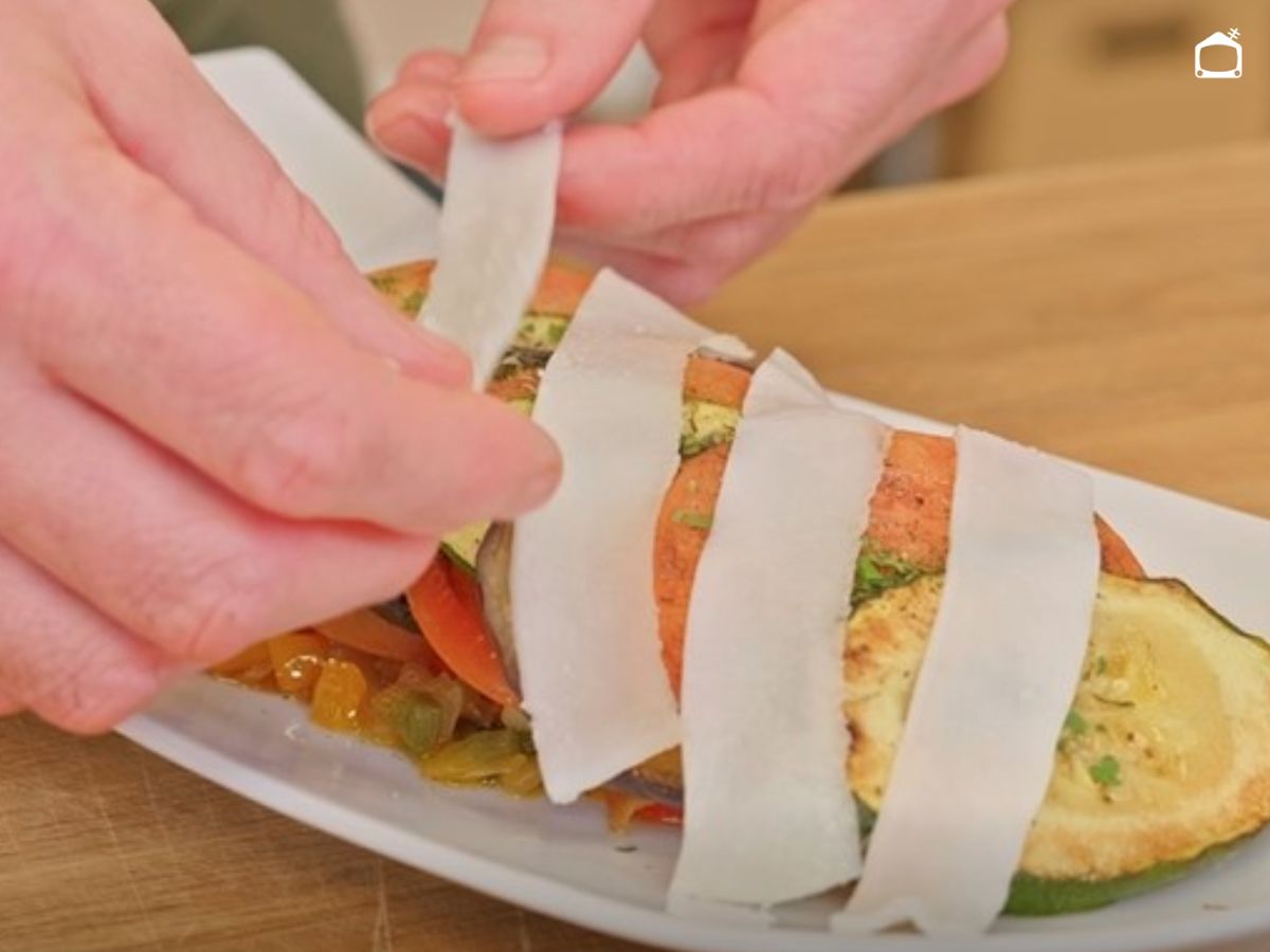 Las lonchas de tocino se reparten por encima antes de llevar la ratatouille al horno.