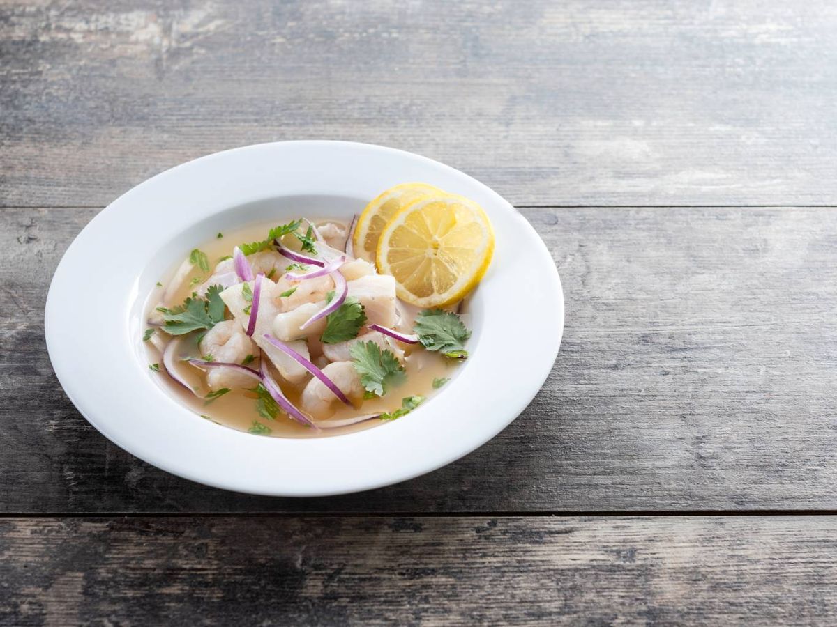 Ceviche peruano con pescado blanco marinado en zumo de limón, cebolla morada y cilantro fresco.