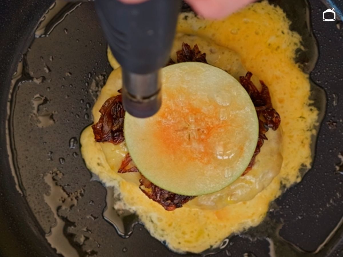 Coloca la cebolla y carameliza la manzana por encima con el soplete