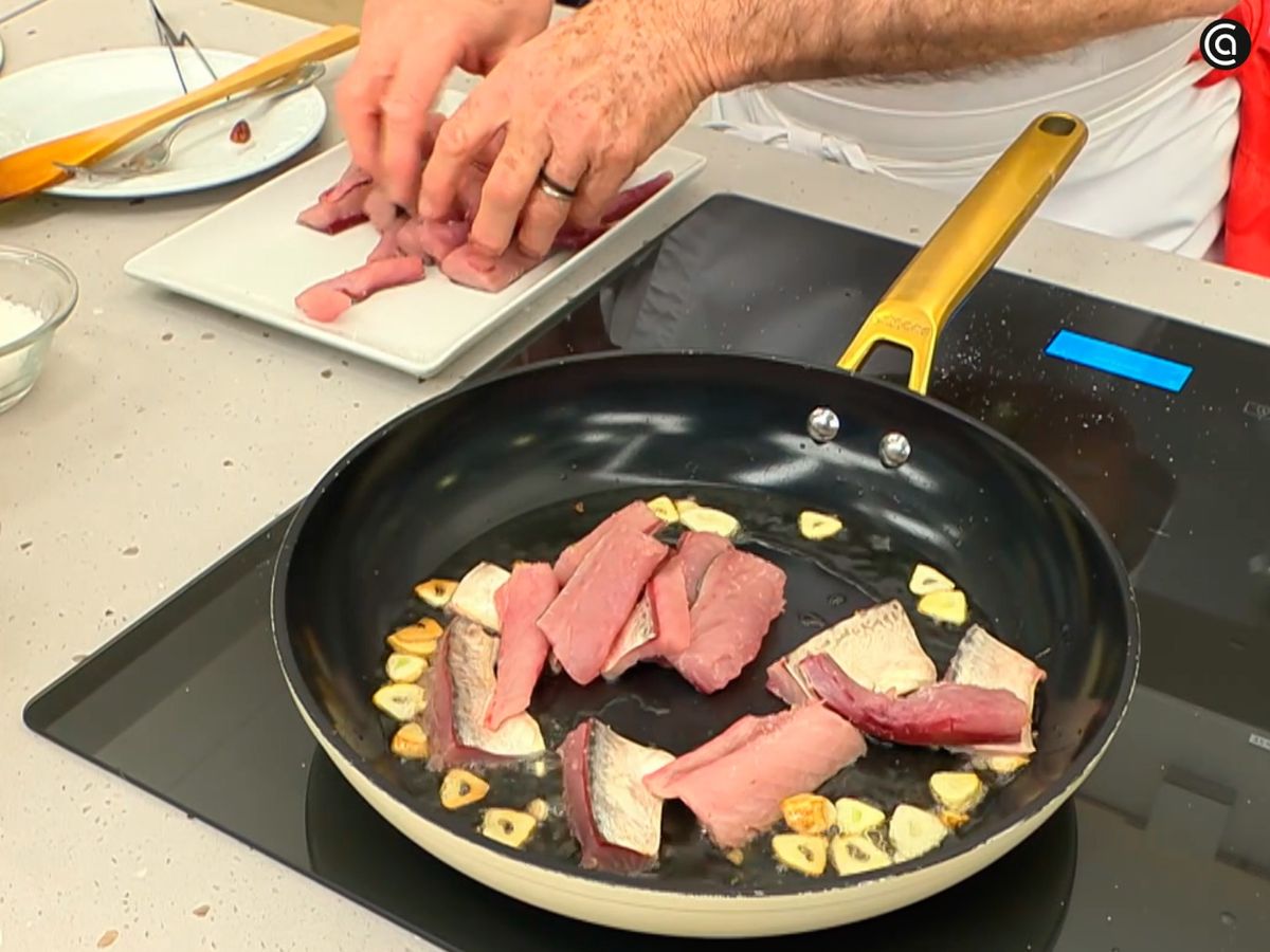 Corta el verdel en lomos y fríelo en aceite con ajos laminados