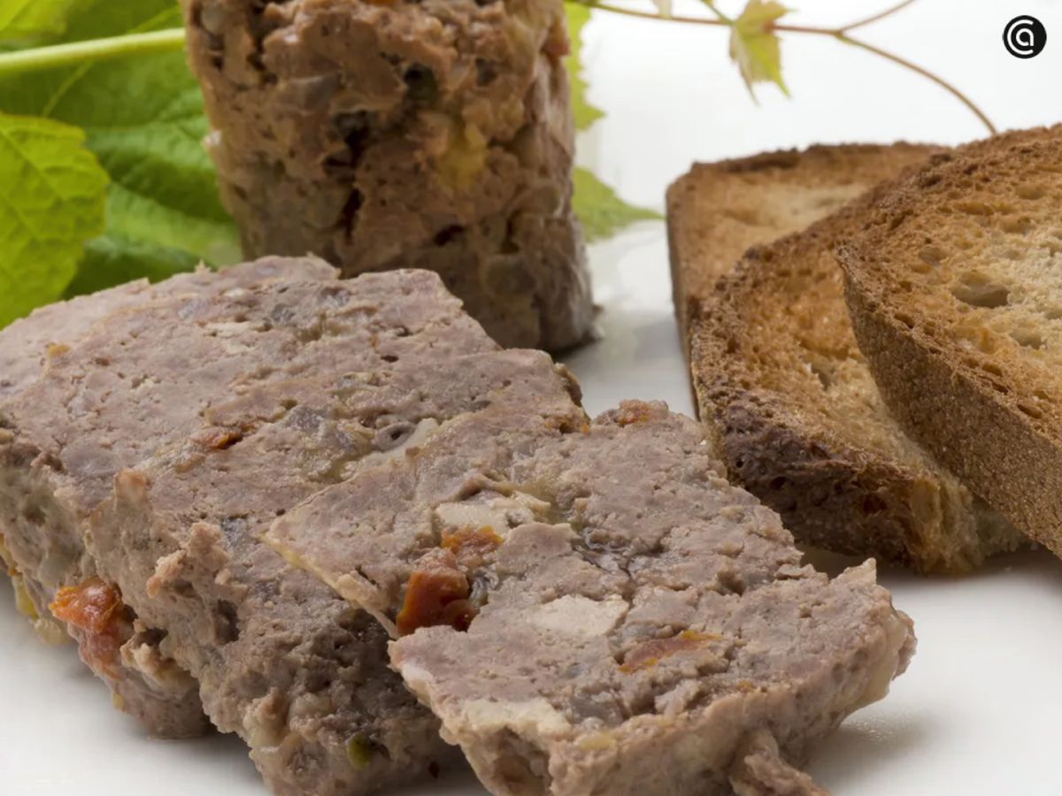 Paté de campaña casero acompañado de tostadas crujientes, listo para servir como aperitivo festivo.