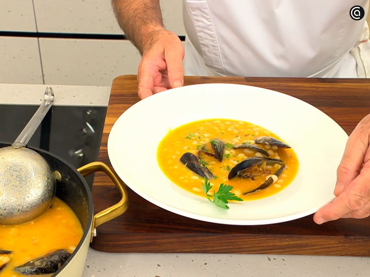 Decora con perejil el plato de alubia blanca con mejillones