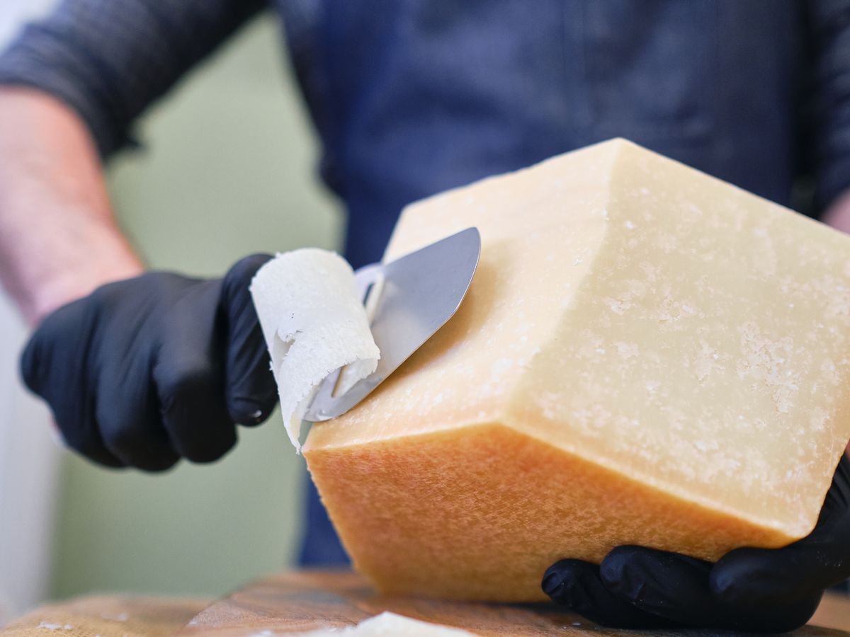 Queso curado listo para cortar en lascas, ideal para pasta y maridajes con vinos.