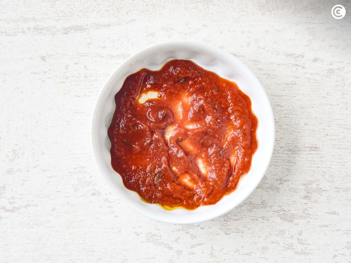 Extender la salsa de tomate como base de los huevos al plato en freidora de aire