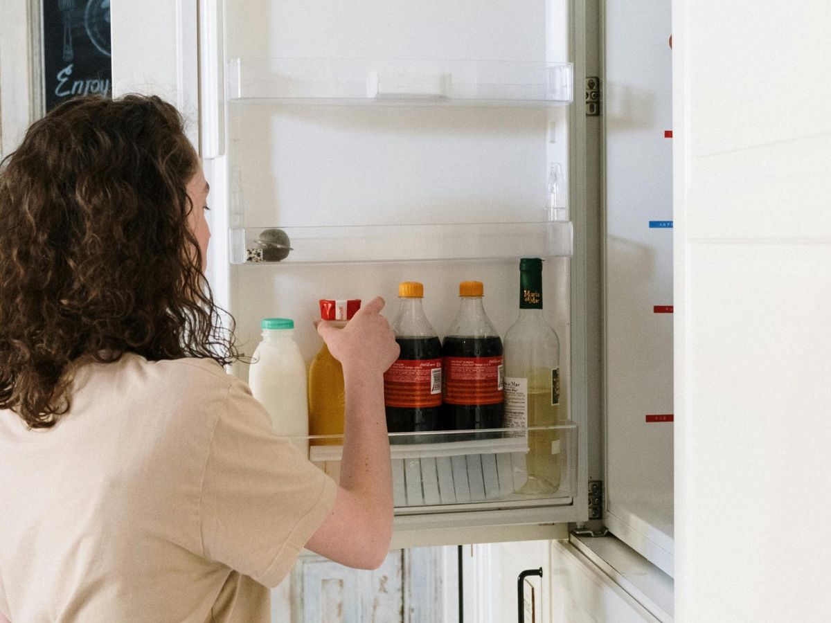 Persona abre la puerta de una nevera