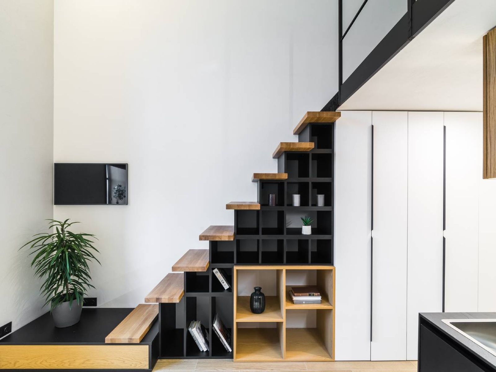Una estantería abierta con módulos decorativos transforma este hueco en un punto focal de diseño. Una estantería abierta con módulos decorativos transforma este hueco en un punto focal de diseño.