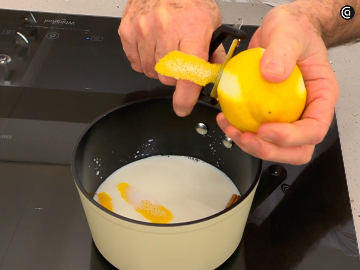 Hierve la leche junto con la canela y la cáscara de limón
