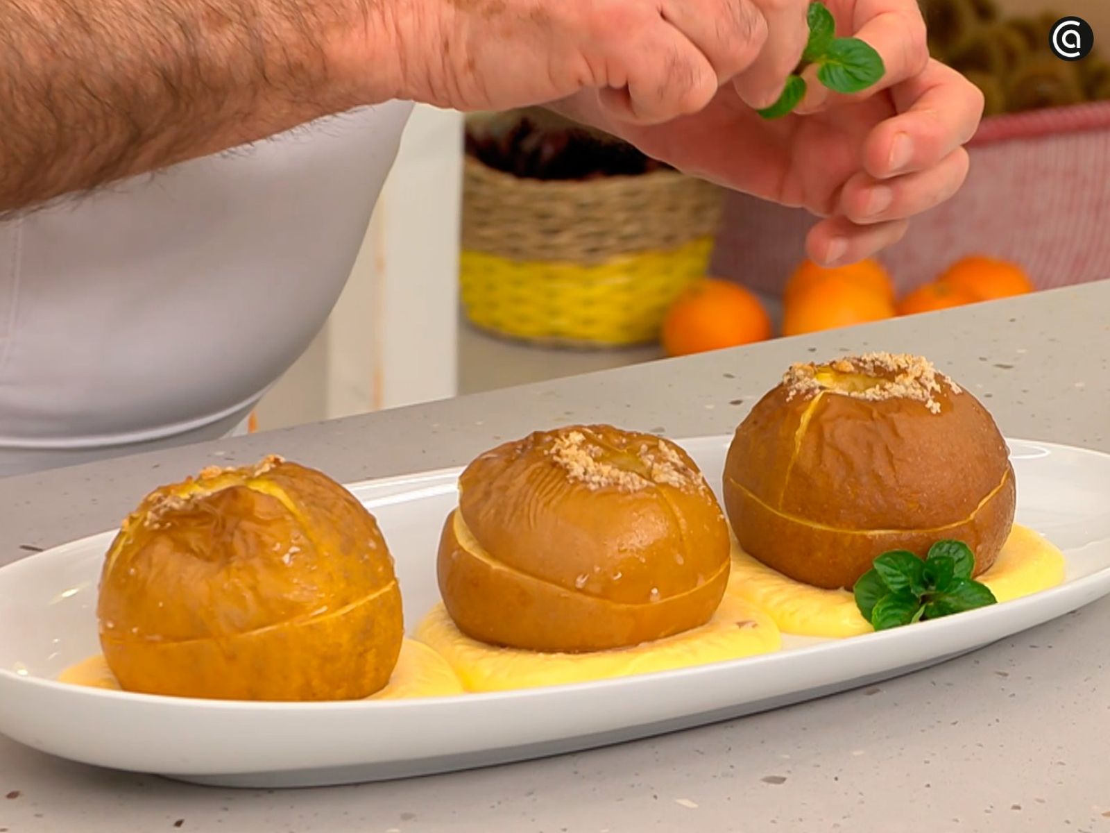 Decora las manzanas asadas con natillas con una hoja de menta