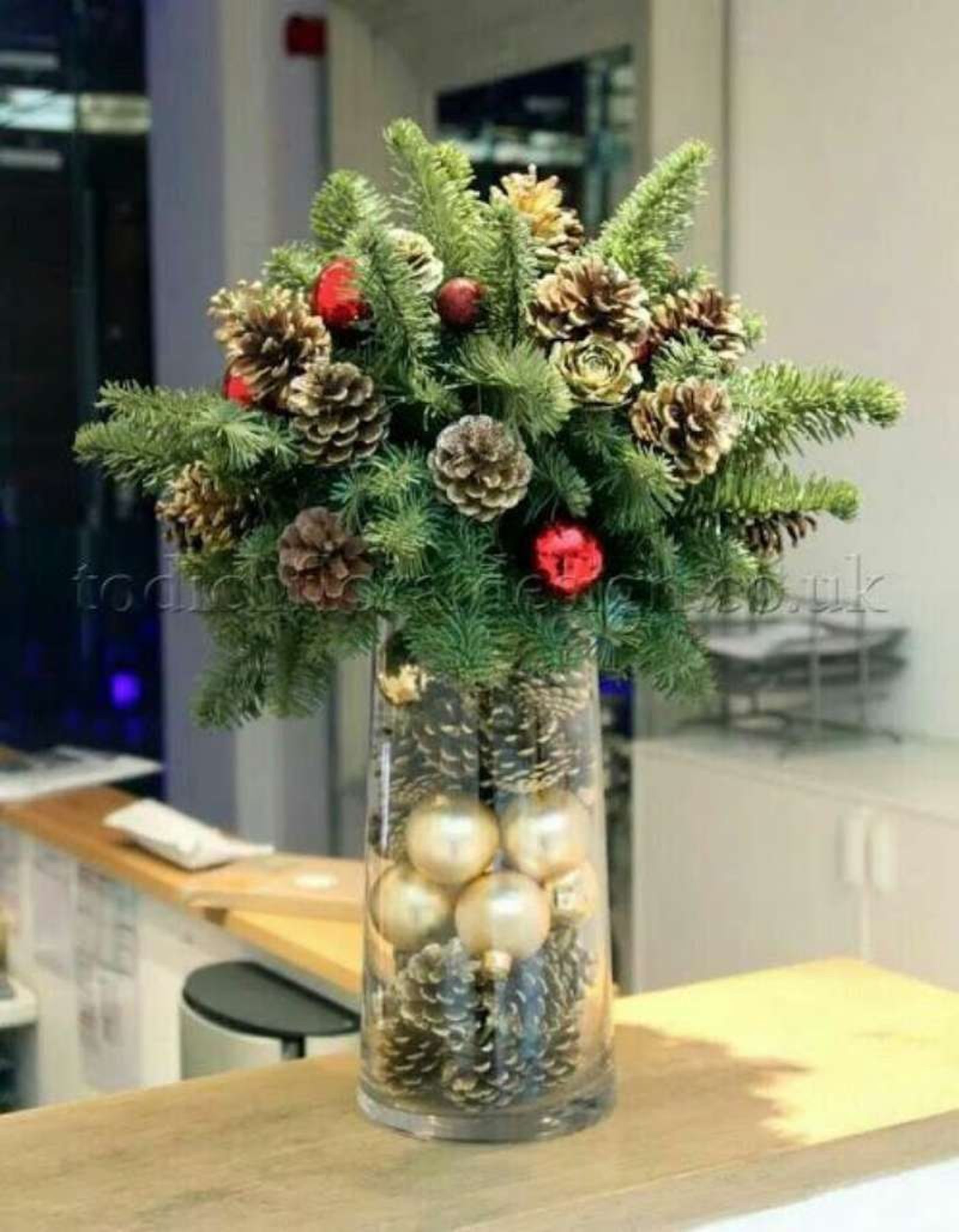 Jarrón de Navidad decorado con piñas secas y bolas. Jarrón de Navidad decorado con piñas secas y bolas.