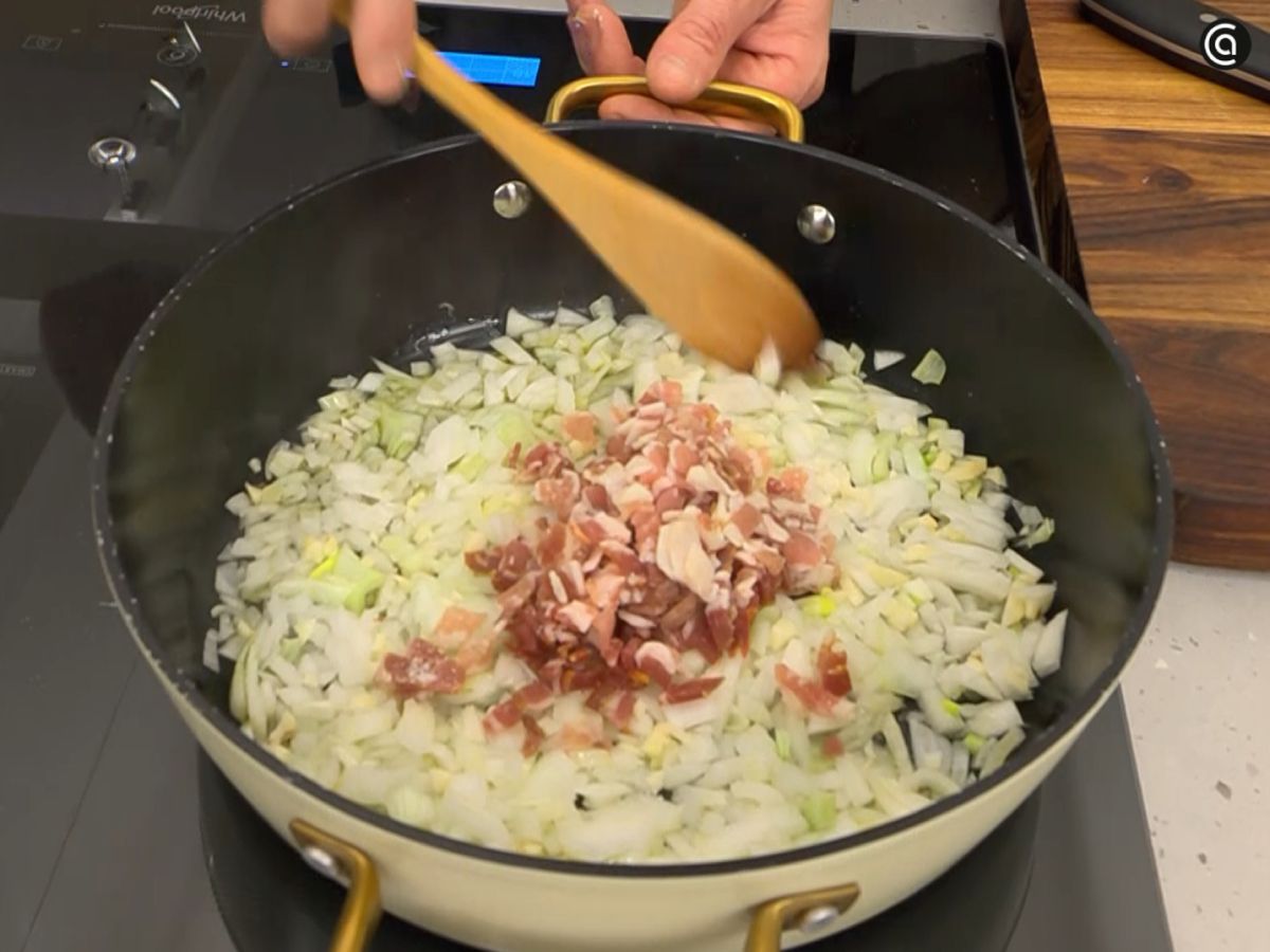La cebolleta, el ajo y la panceta se doran en la cazuela para iniciar la salsa de tomate.