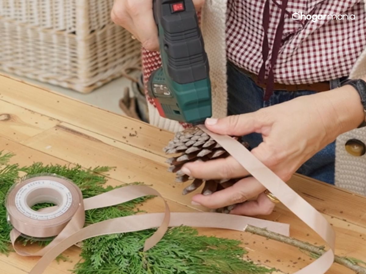Sujeta la cinta a las piñas para convertirlas en colgantes decorativos llenos de encanto.