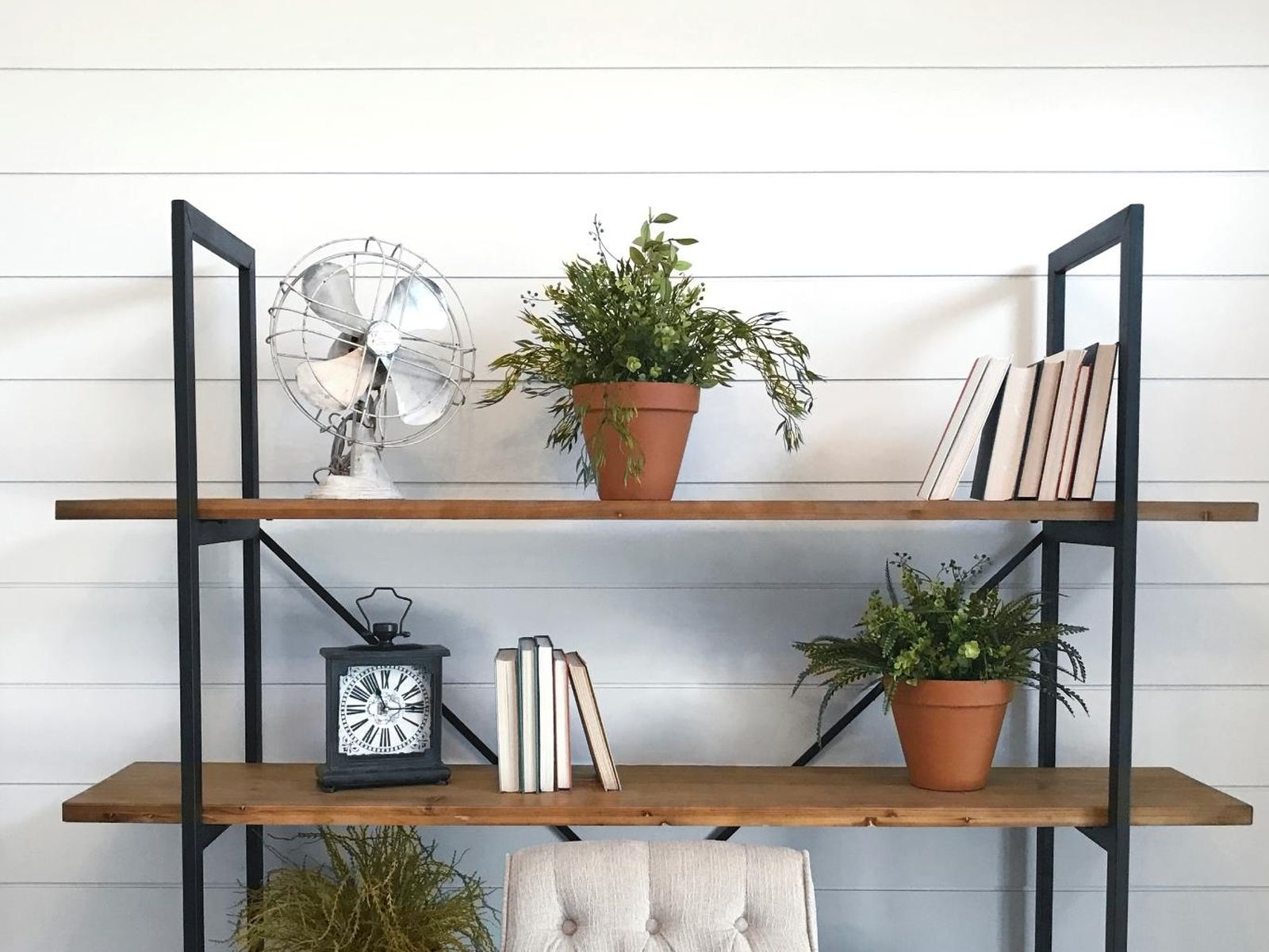 Estantería metálica con plantas y decoración.