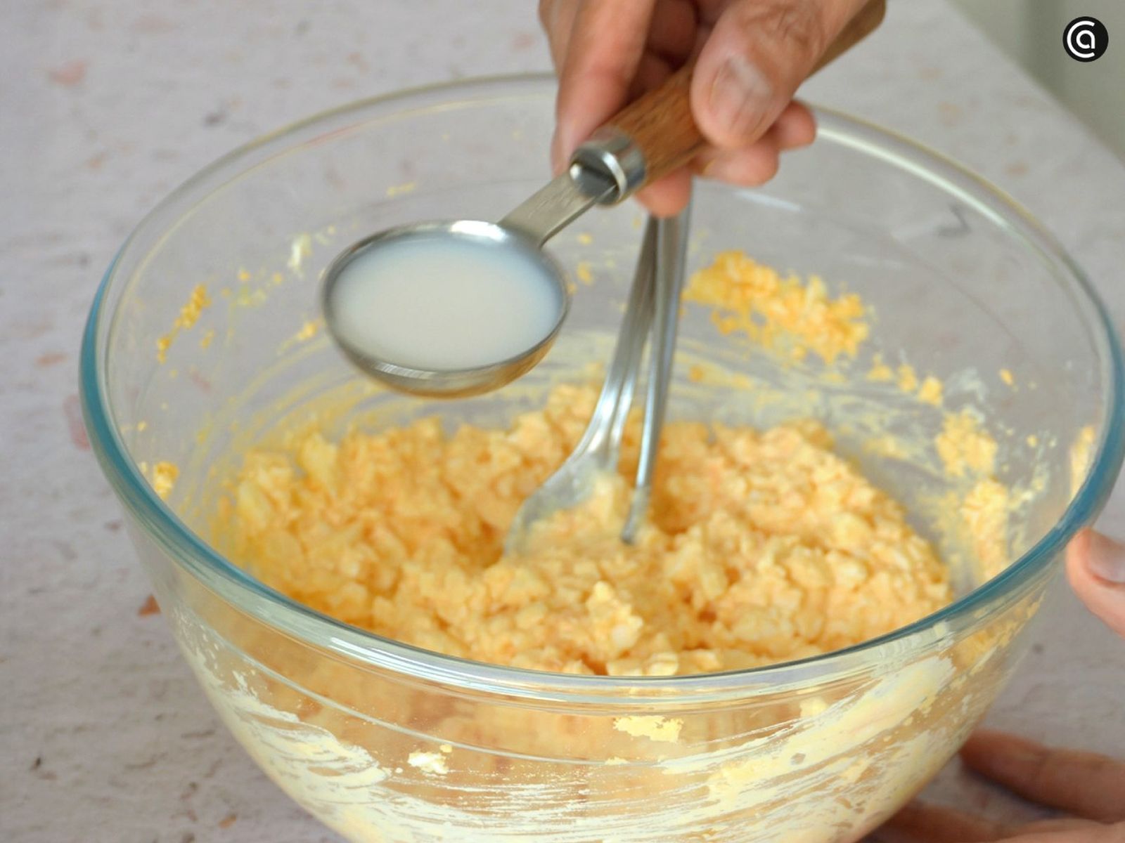 Mezcla claras y yemas con mayonesa, mostaza y sal, y agrega la leche tamago sando receta paso2