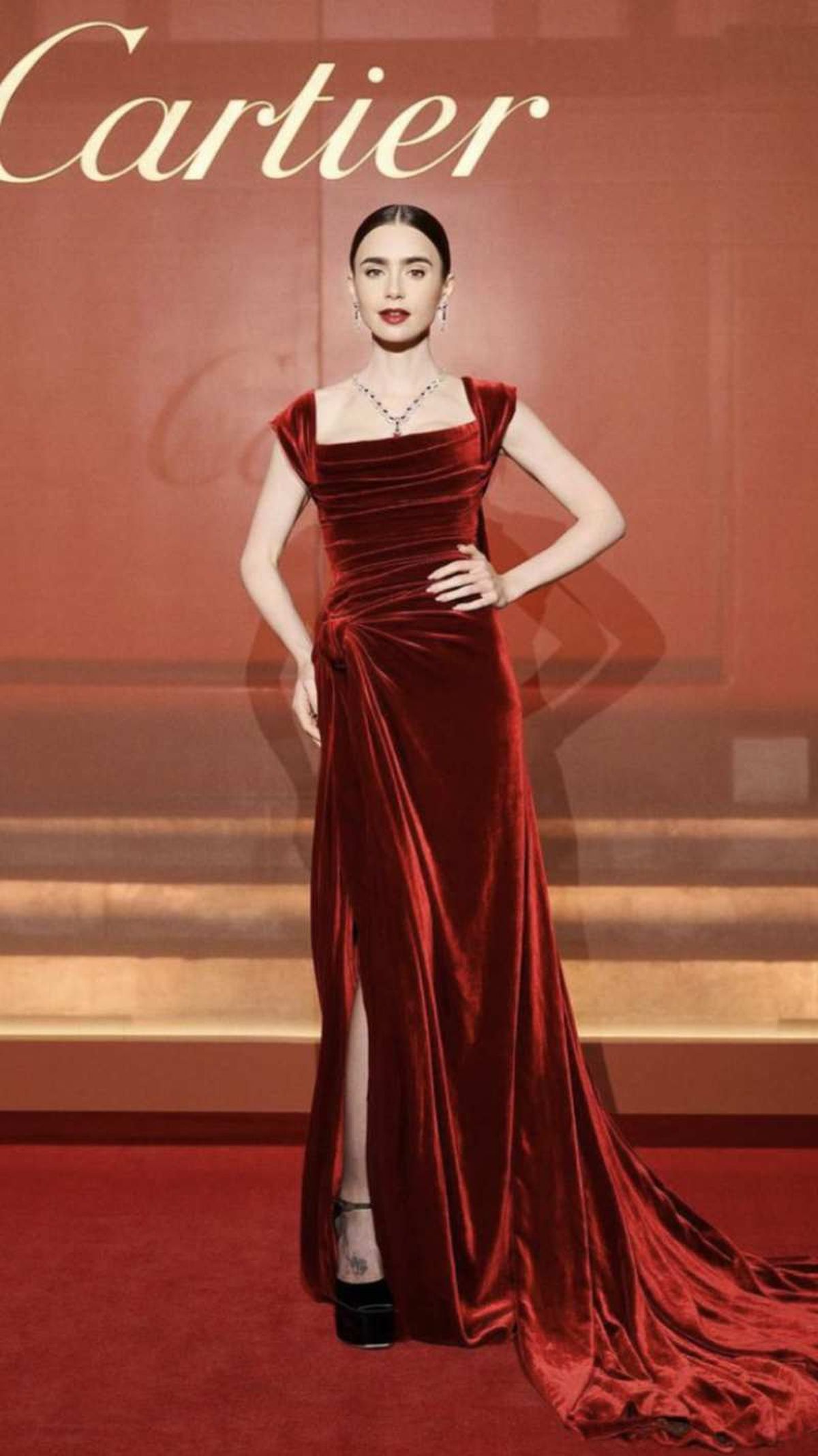 Lily Collins con vestido largo de terciopelo en color burdeos
