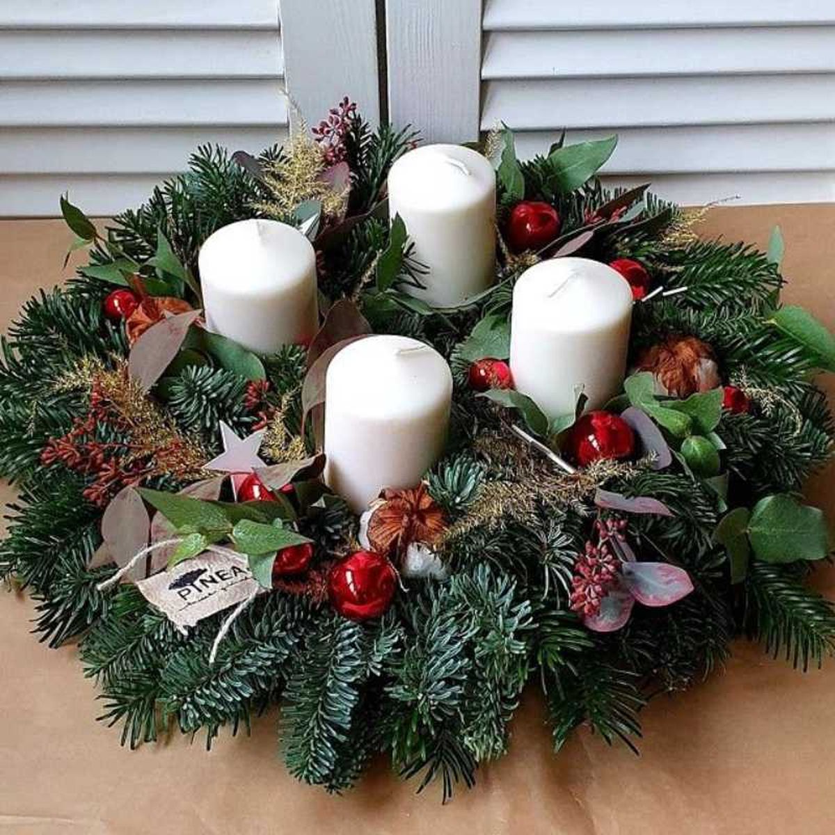 Corona de Navidad con velas en la ventana.