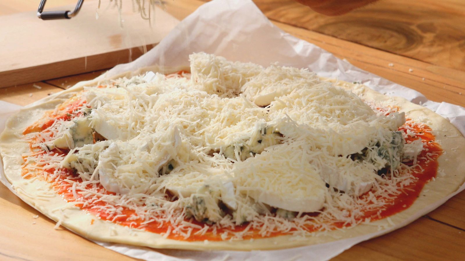 Reparte los quesos cubriendo la superficie Pizza cuatro quesos Paso 2
