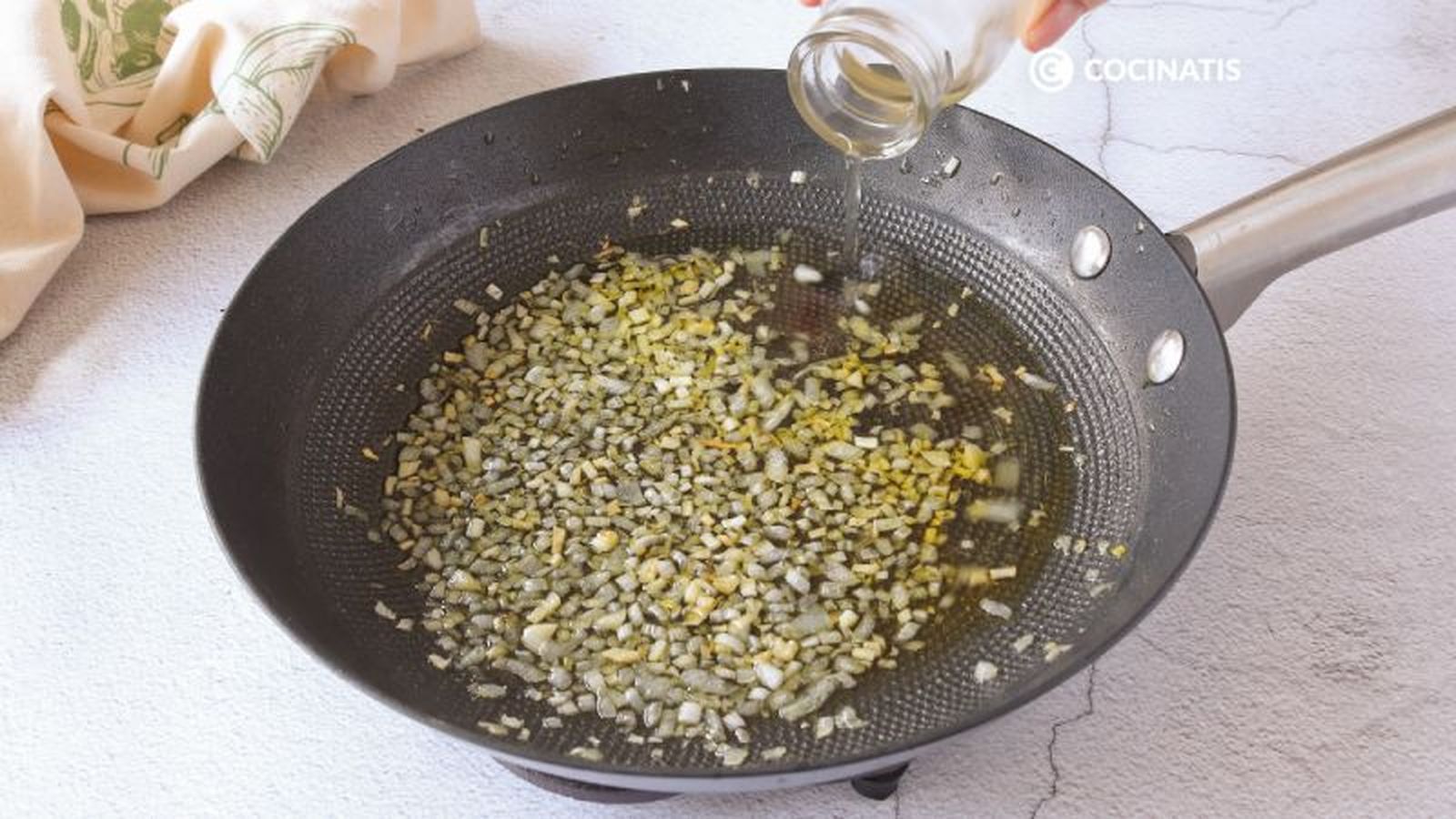Agregamos el vino blanco a la cebolla en la sartén Agregamos el vino blanco a la cebolla en la sartén