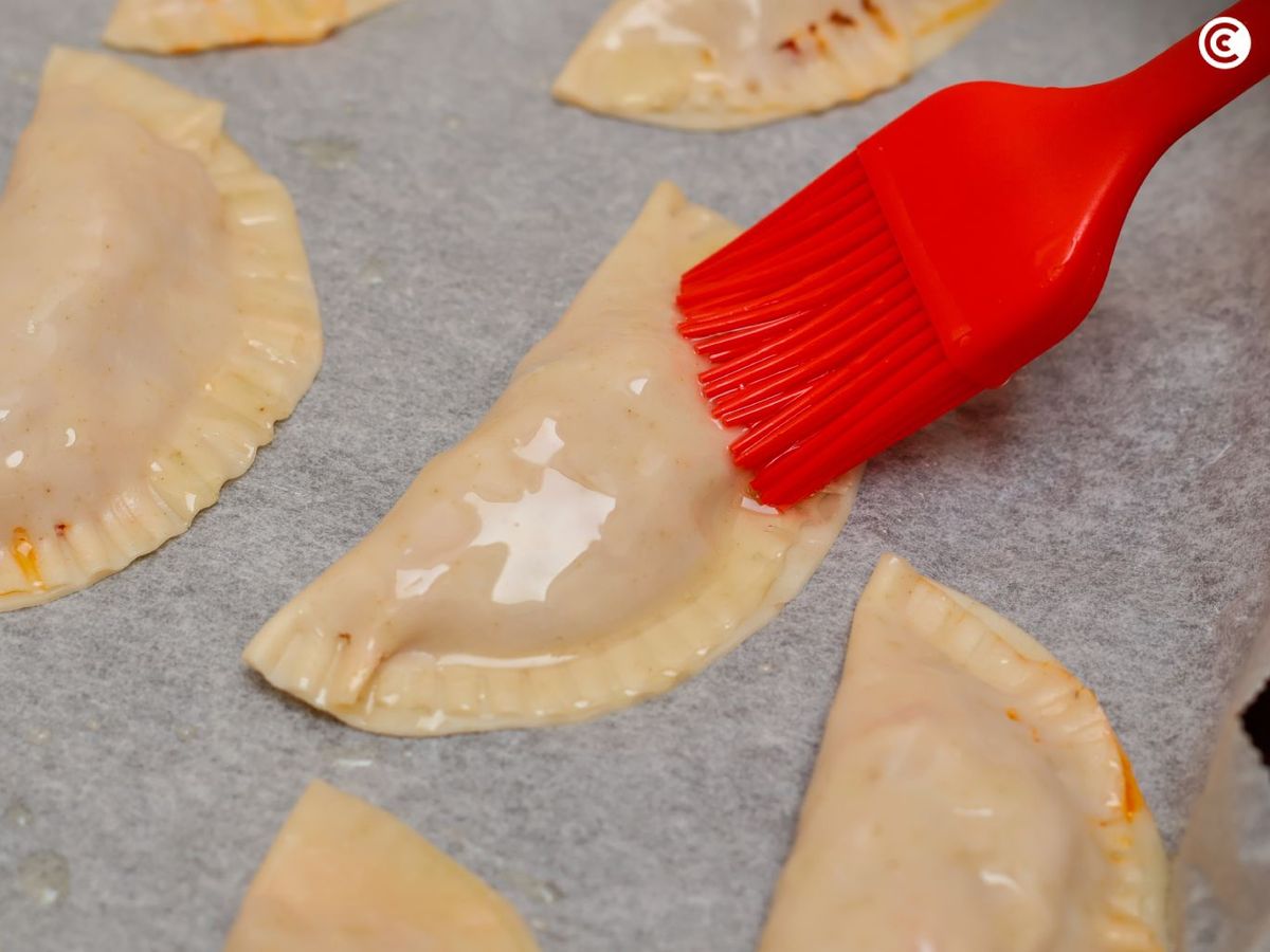 Pintar las empanadillas de verduras con aceite para hornearlas