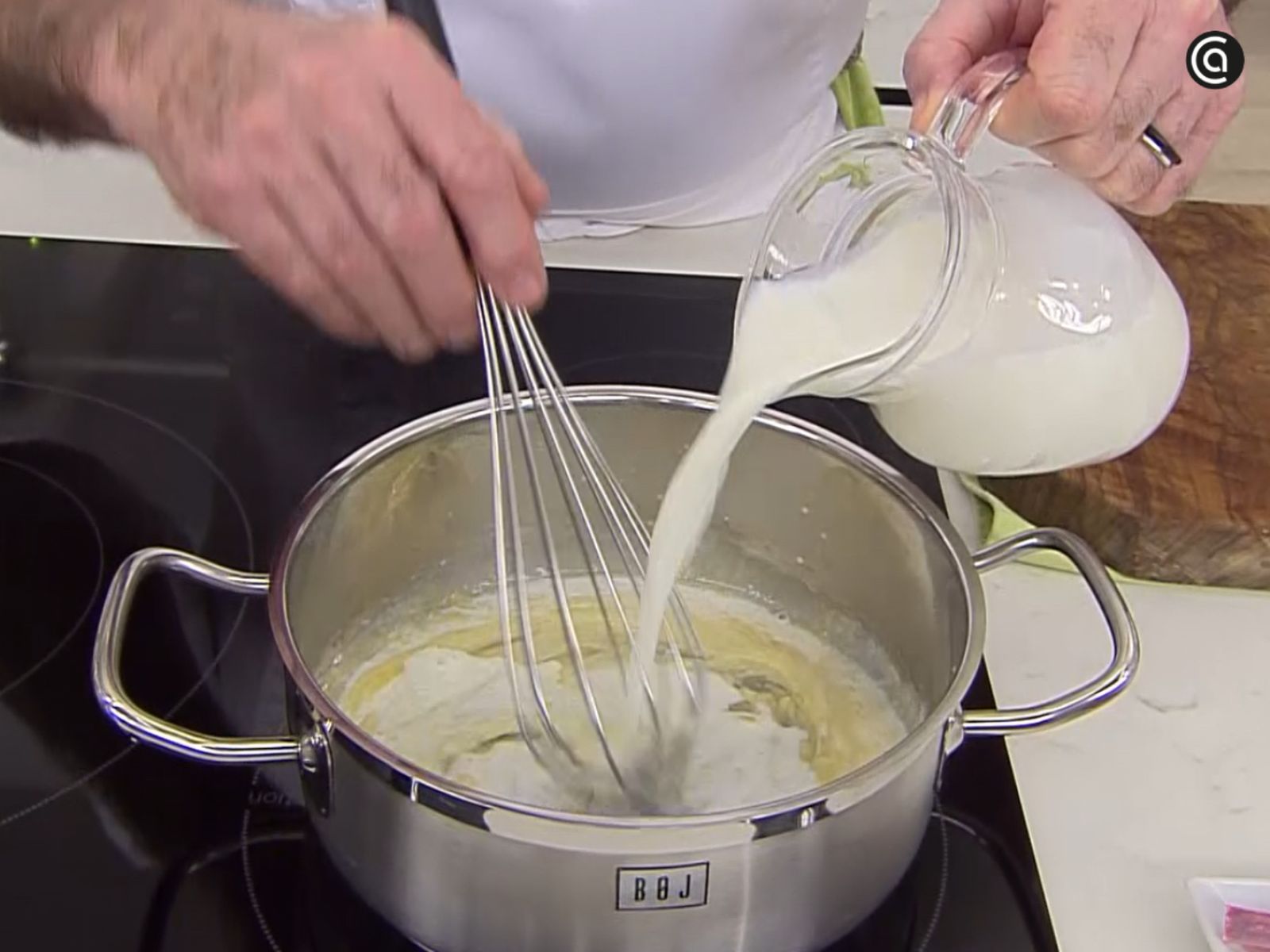 La leche se incorpora mientras se trabaja la mezcla con varillas para conseguir una textura lisa.