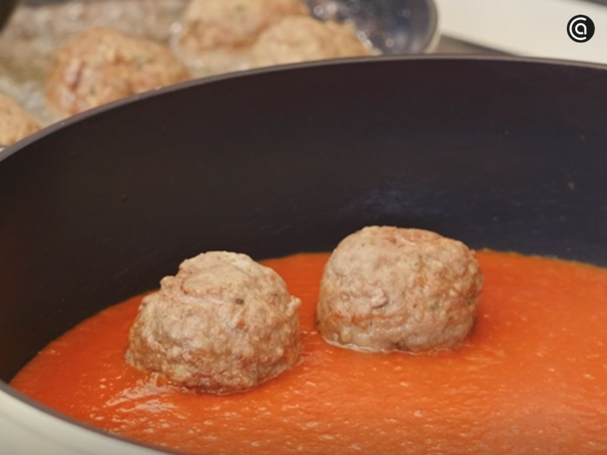 Las albóndigas se terminan de cocinar en la salsa de tomate caliente.