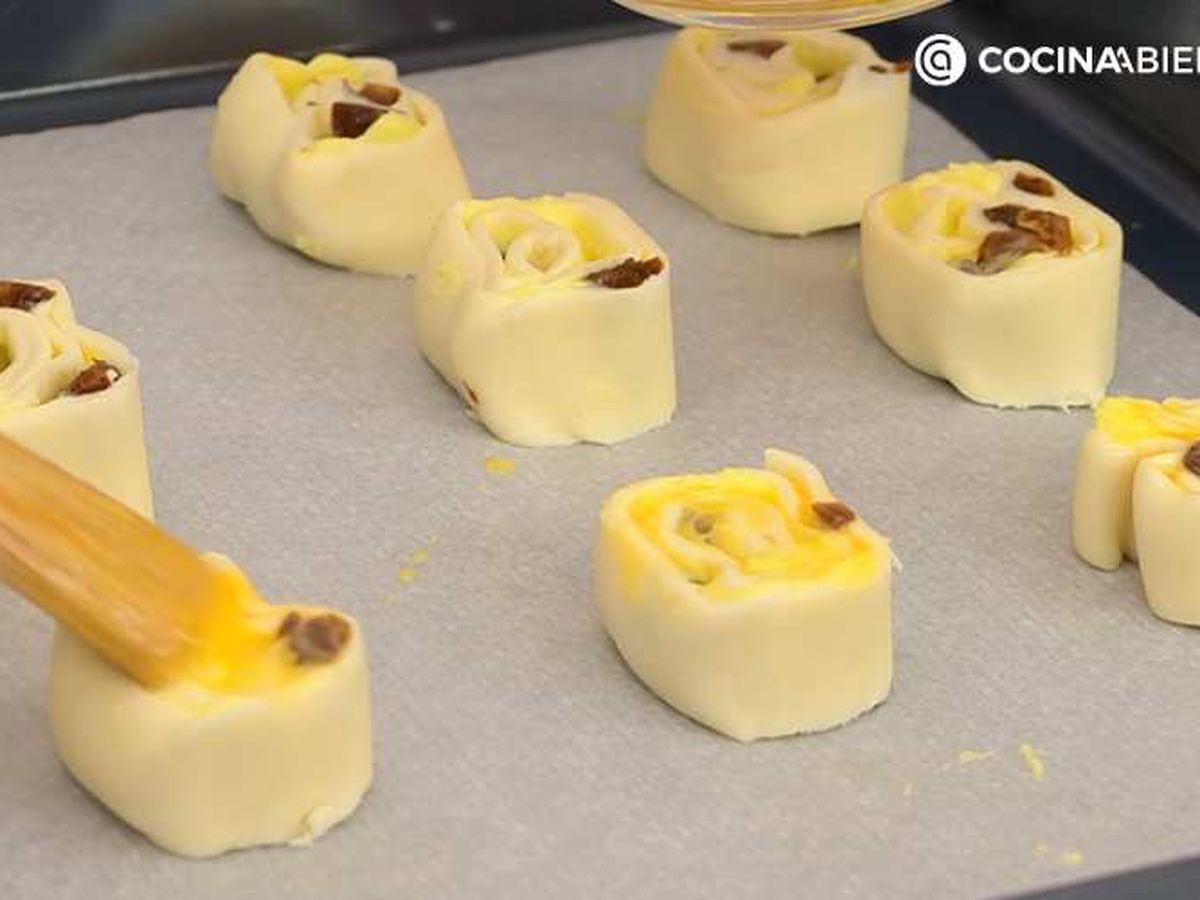 Pinta las caracolas de crema y pasas con huevo batido