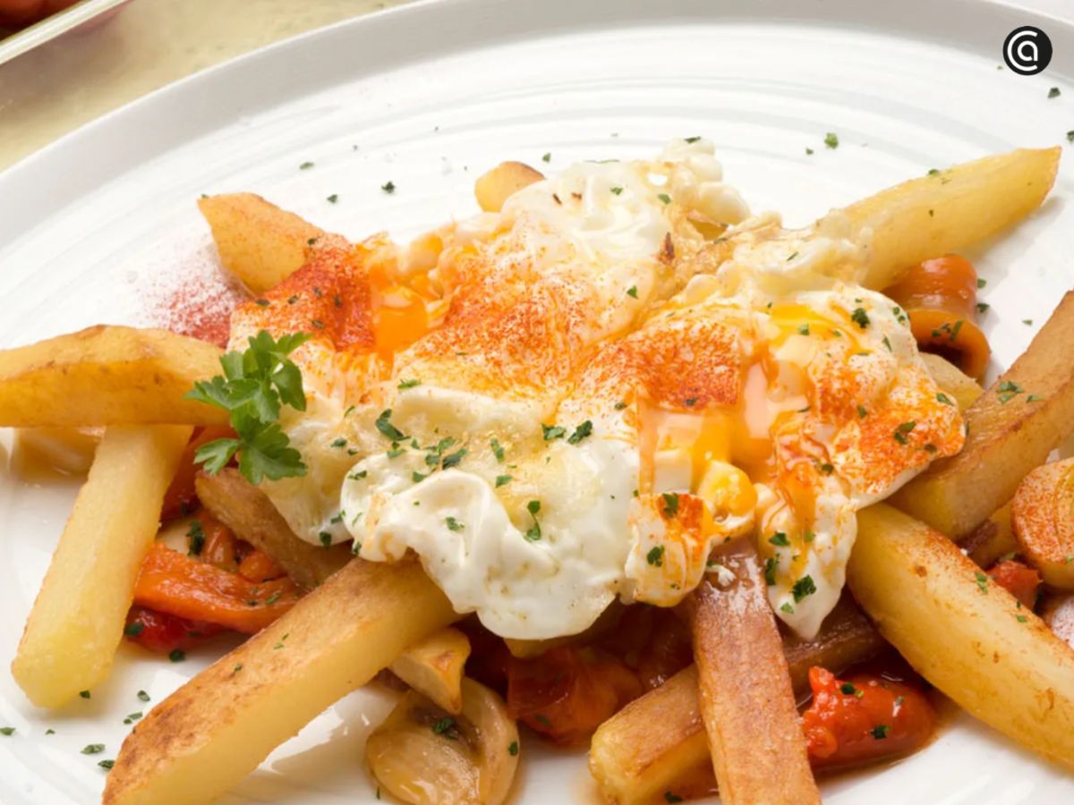 El contraste entre lo crujiente de las patatas y el dulzor de los pimientos eleva estos huevos rotos.