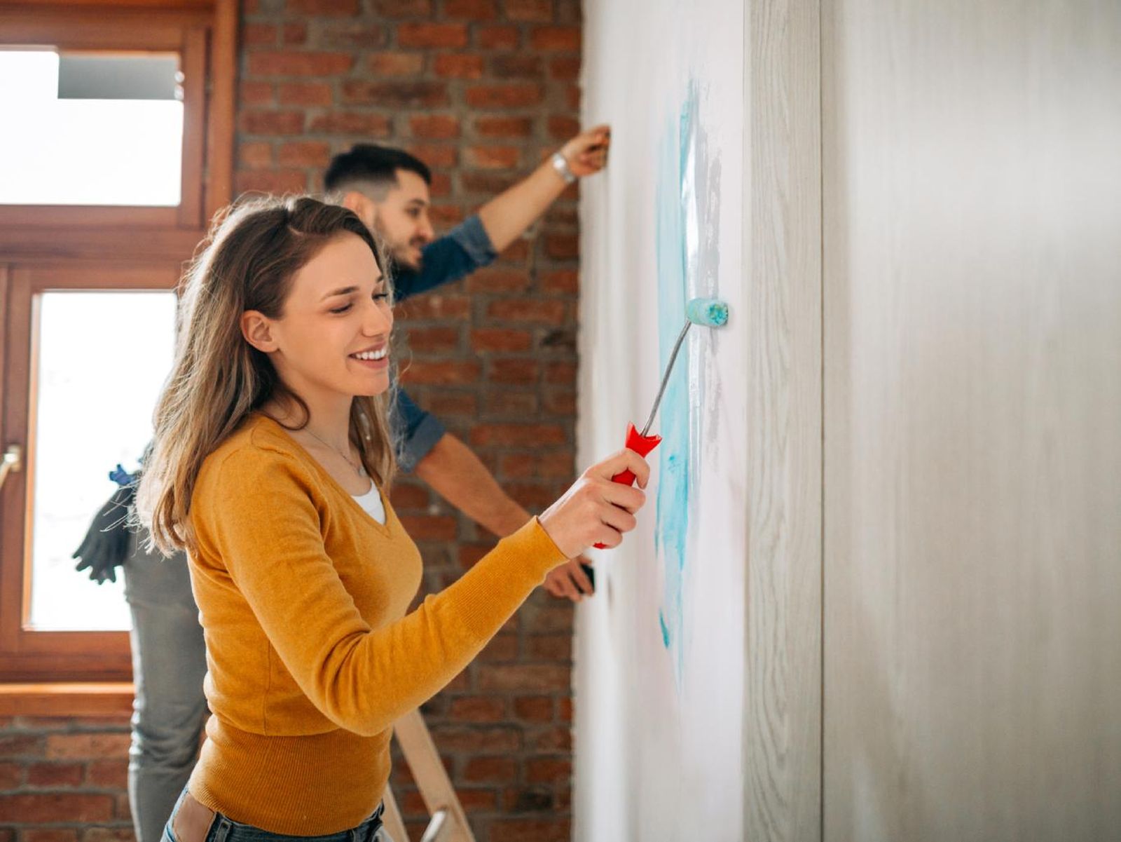 Pareja pintando las paredes.