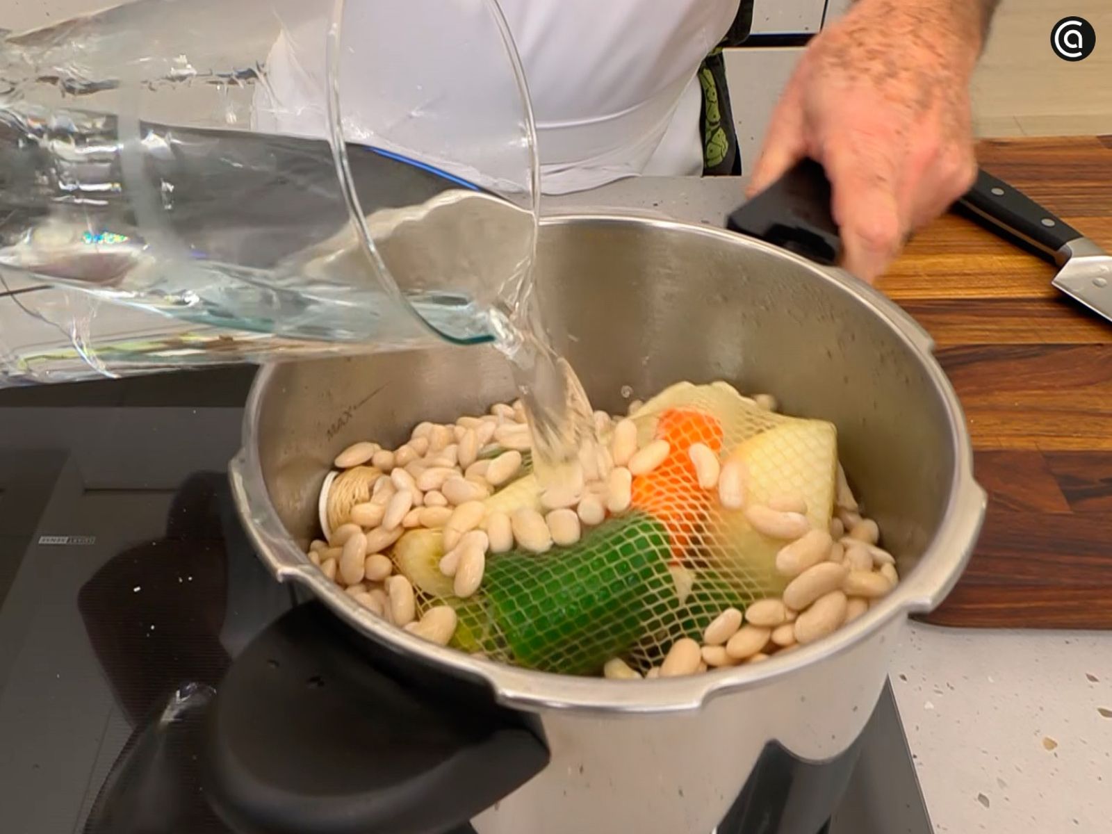 Incorpora las verduras junto con las alubias, vierte agua hasta cubrir y cocina