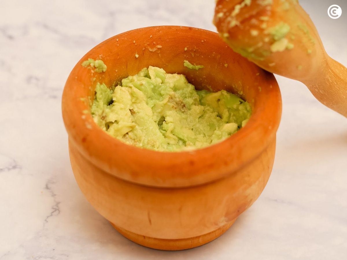Machacar el aguacate para acompañar los nachos