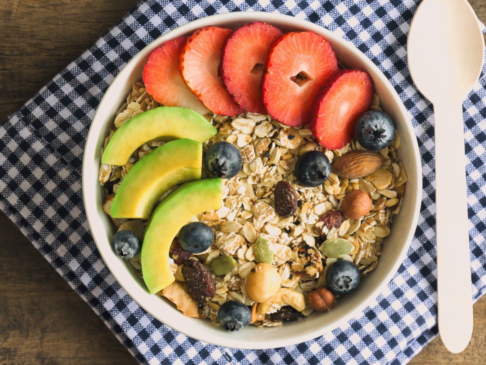Prepara un bol de granola con aguacate, yogur o leche vegetal y añade los toppings que más te gusten