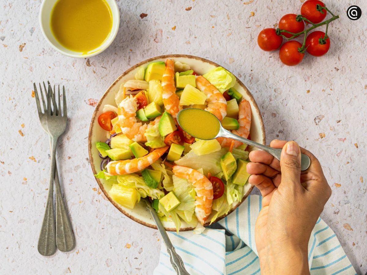 Mezcla todo y aliña la ensalada tropical con la vinagreta