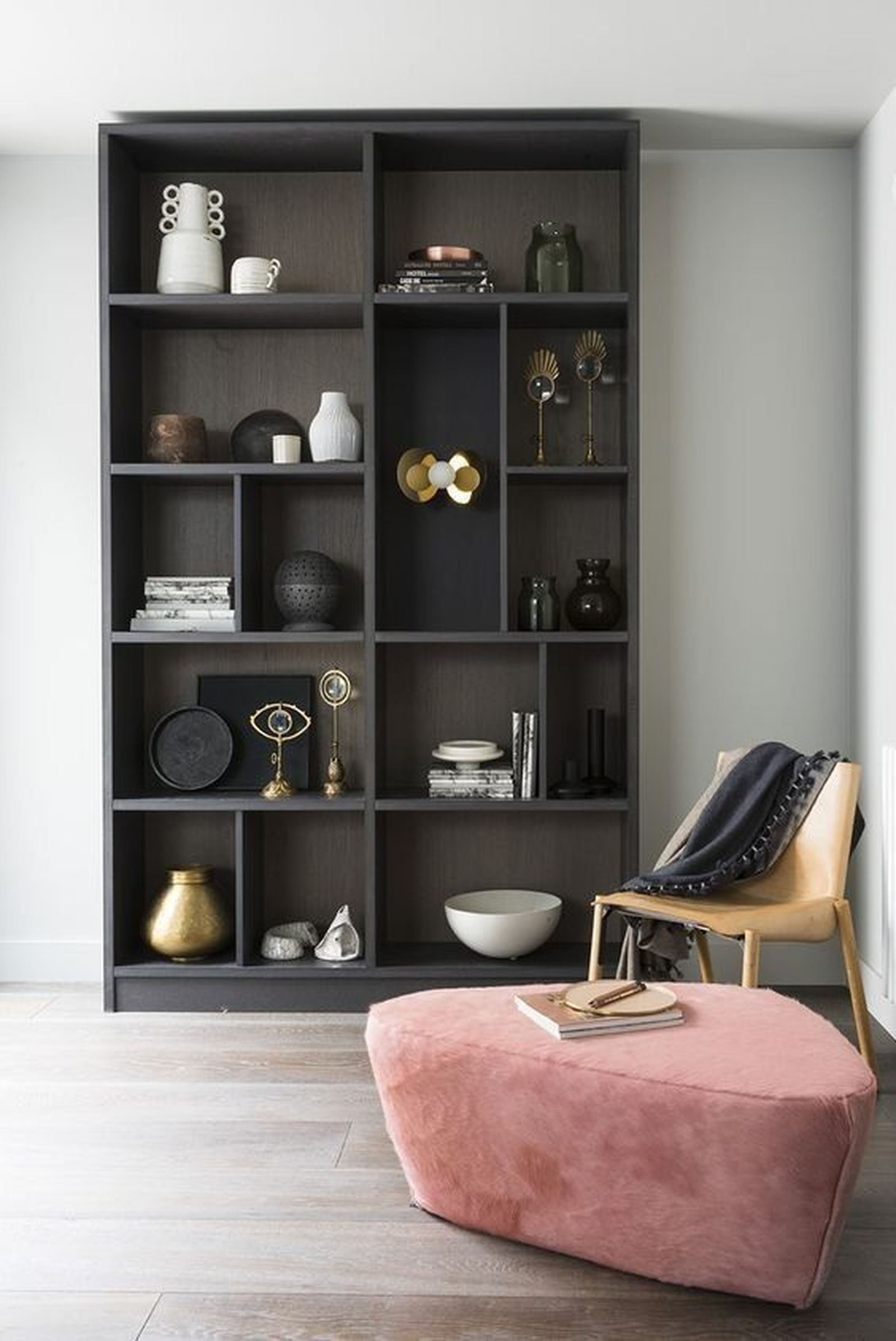 Estantería de madera oscura con butaca rosa. Estantería de madera oscura con butaca rosa.
