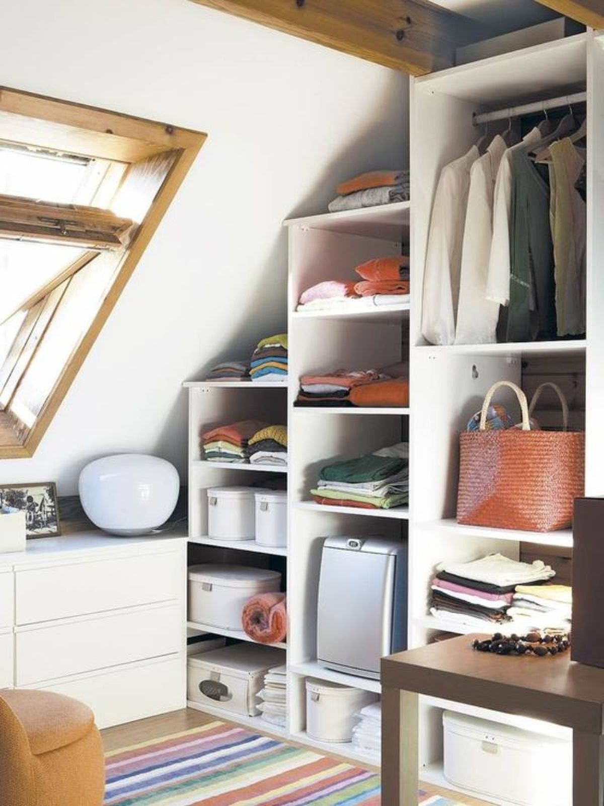 Buhardilla con vestidor pequeño con muebles en escalera.
