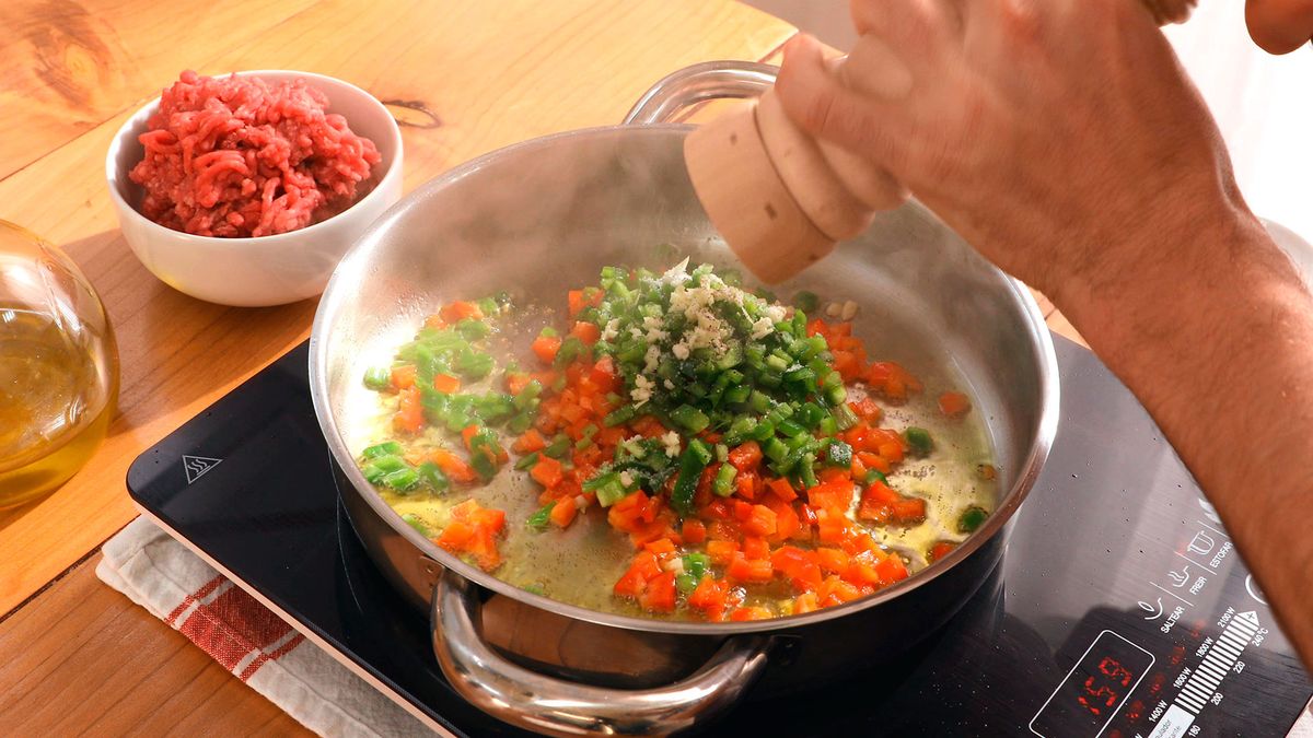 Saltea pimientos y ajo en aceite, sazonando con sal y pimienta para realzar los sabores