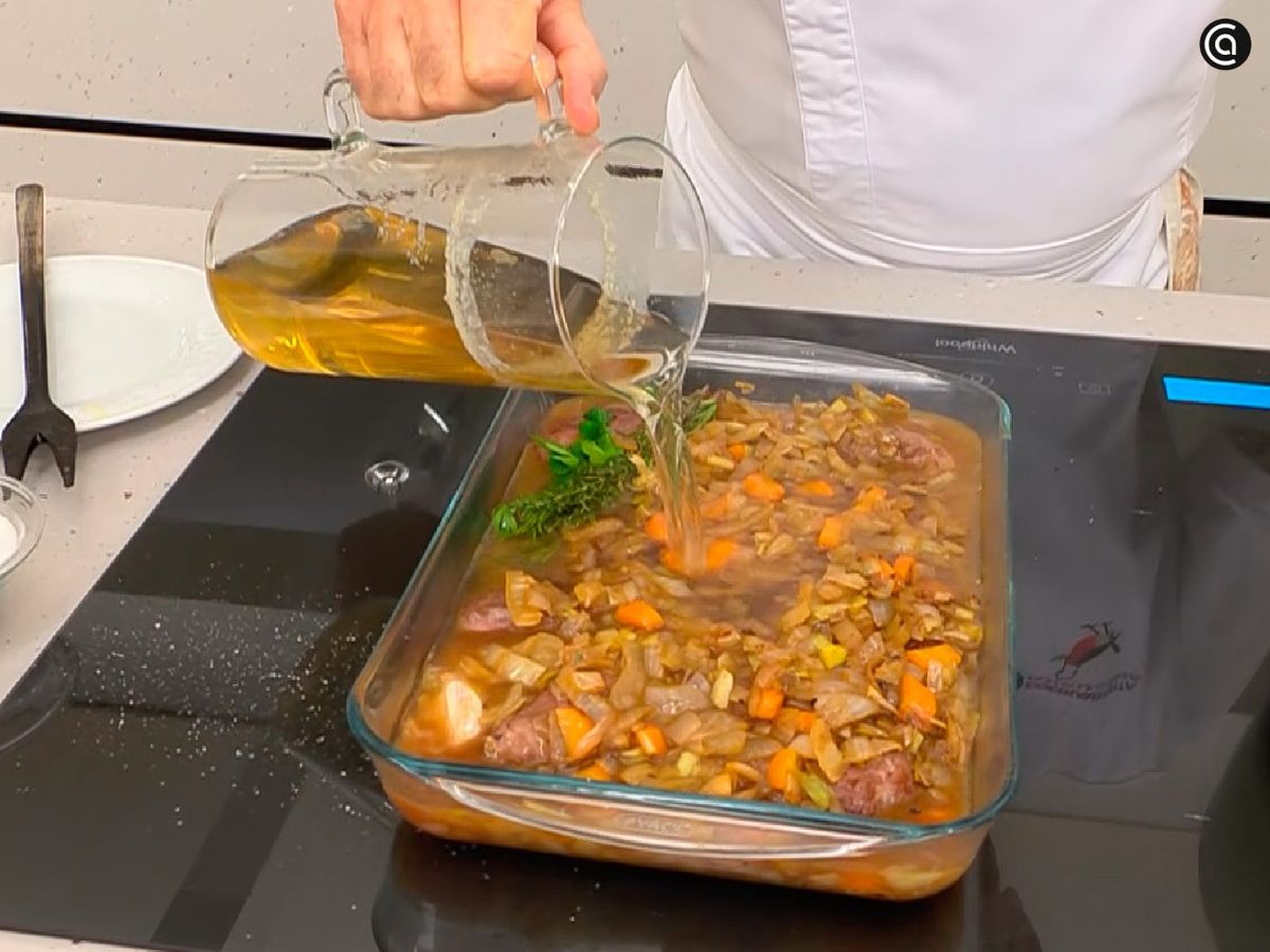 Añade las hortalizas y el caldo sobre las carrilleras y cocina en el horno