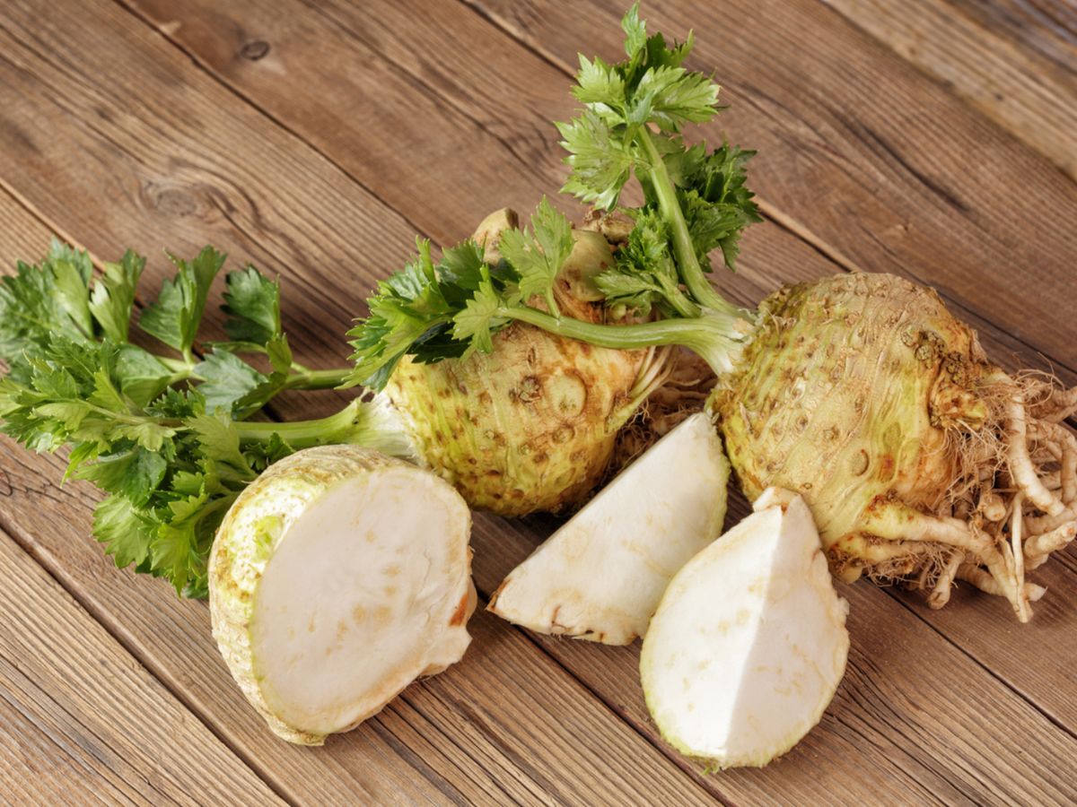 Raíz de apionabo fresca con hojas verdes, ideal para recetas asadas o en puré.