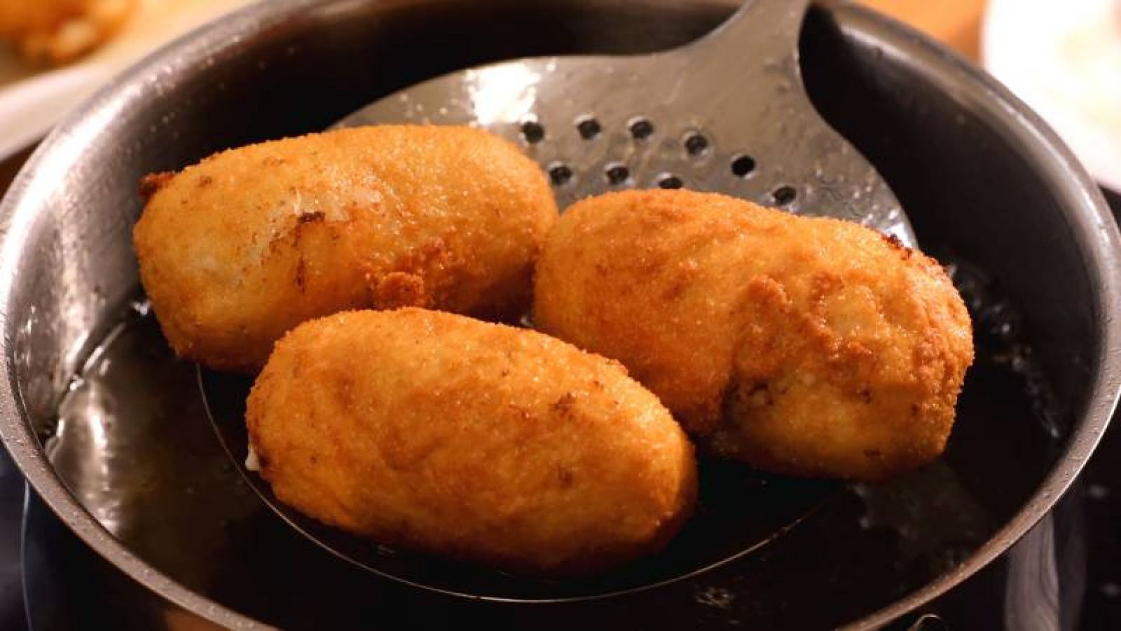 Freír las croquetas en aceite caliente hasta que estén doradas asegura una textura crujiente por fuera y cremosa por dentro Freír las croquetas en aceite caliente hasta que estén doradas asegura una textura crujiente por fuera y cremosa por dentro