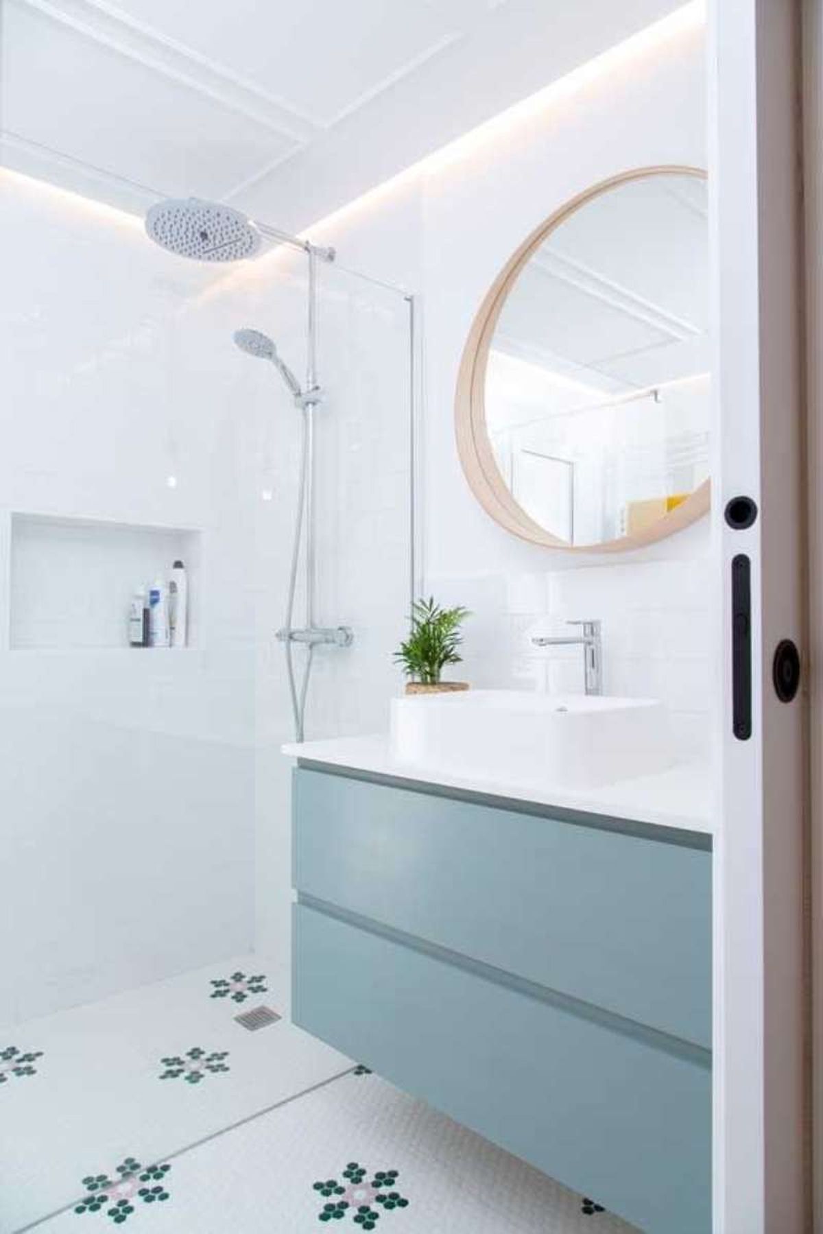 Baño de estilo nórdico con ducha y mueble azul.
