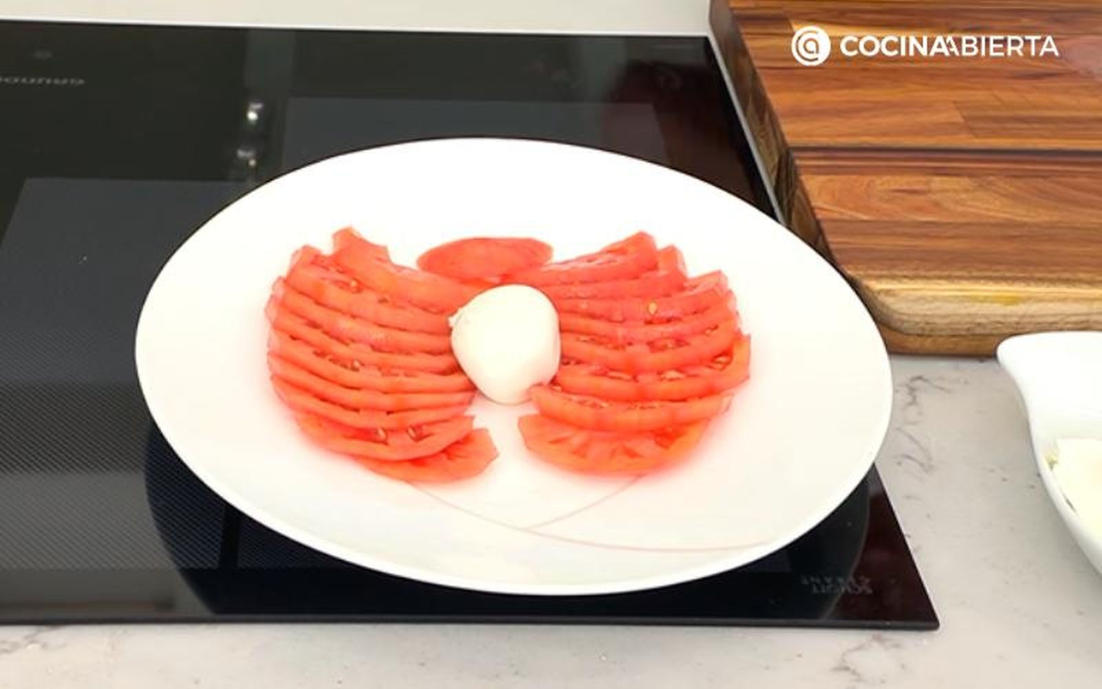 Pon las rodajas de tomate y la burratina en un plato