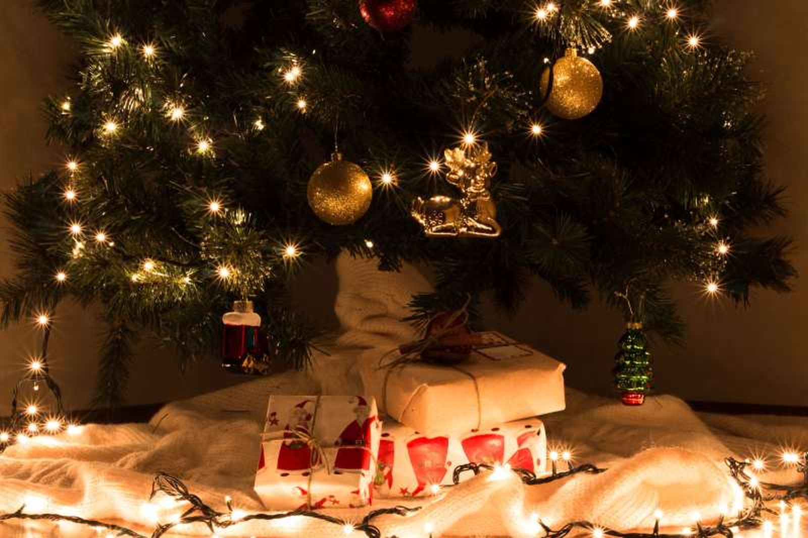 Pie del árbol de Navidad decorado con una manta y regalos. Pie del árbol de Navidad decorado con una manta y regalos.